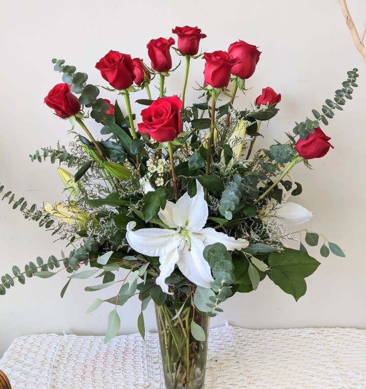 Bouquet of red roses and white lilies in a clear glass vase