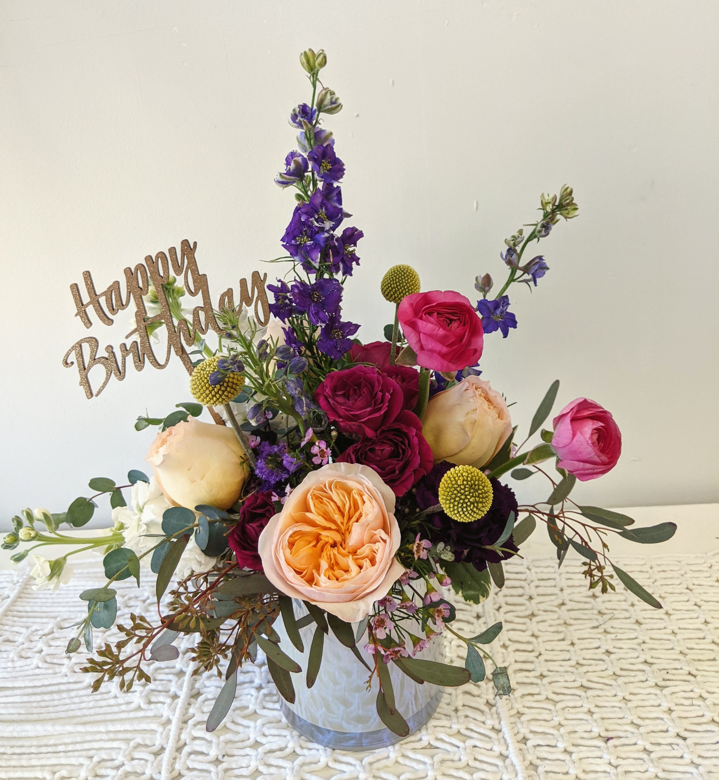 Mixed bouquet in a clear vase with a Happy Birthday sign