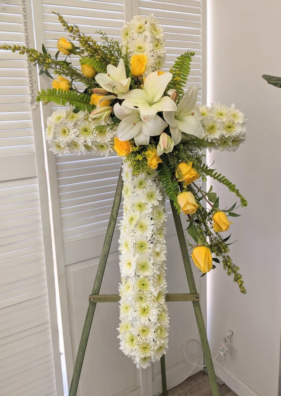 In Our Prayers Standing Spray - A cross on an easel that is mostly white with pops of yellow .