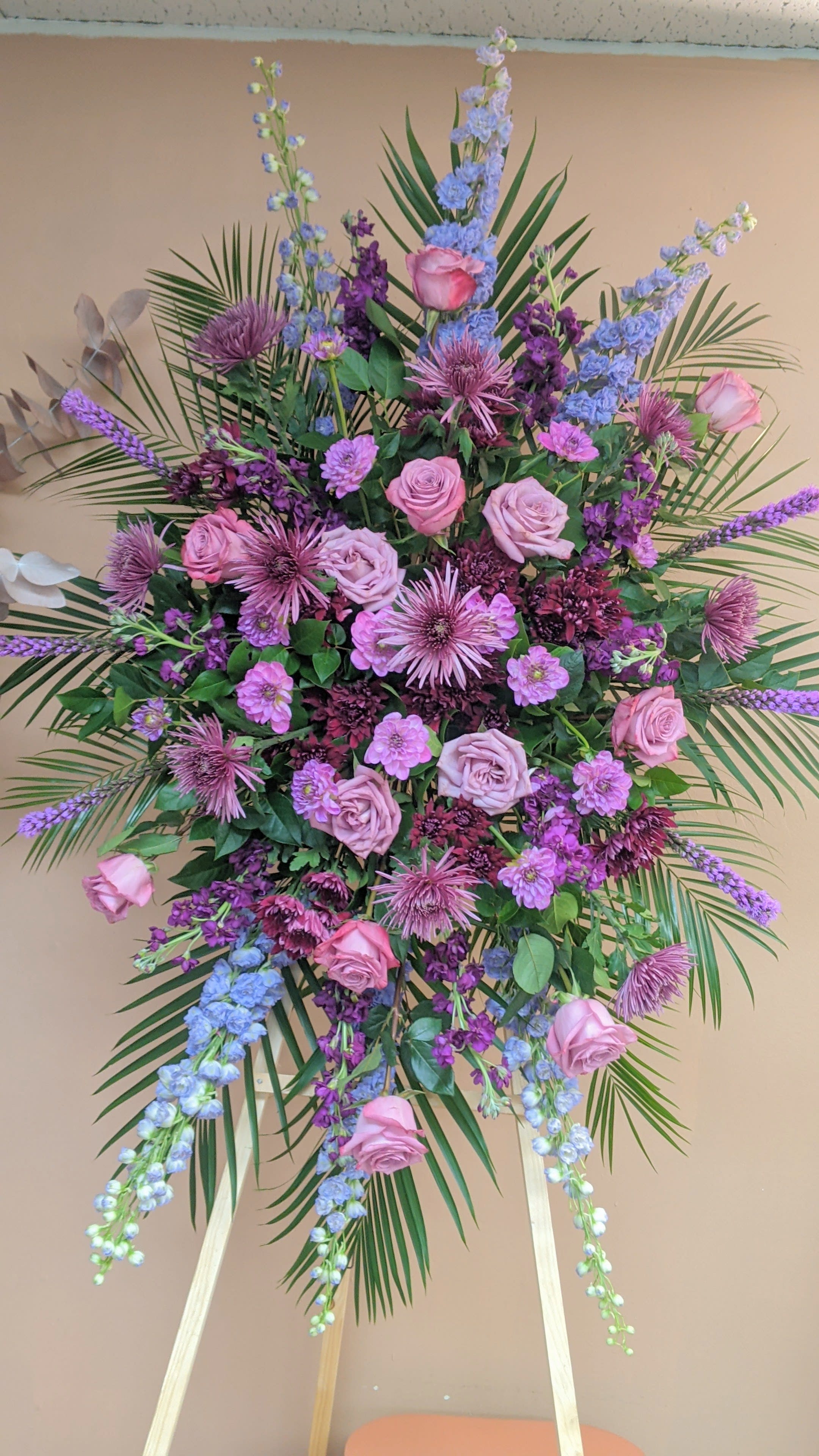 Large standing floral spray with pink roses and purple blooms