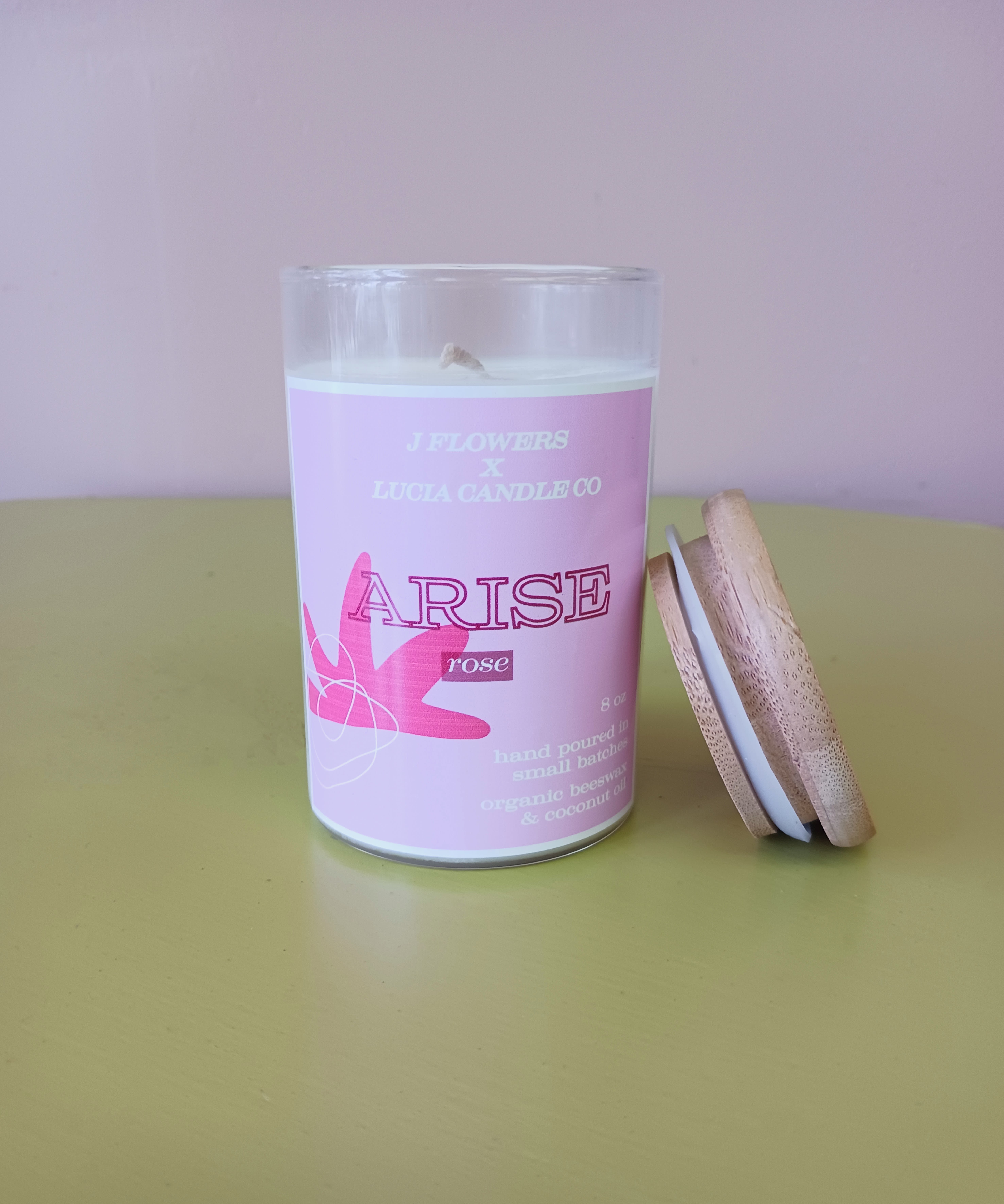 Pink rose candle in a glass jar with a wooden lid