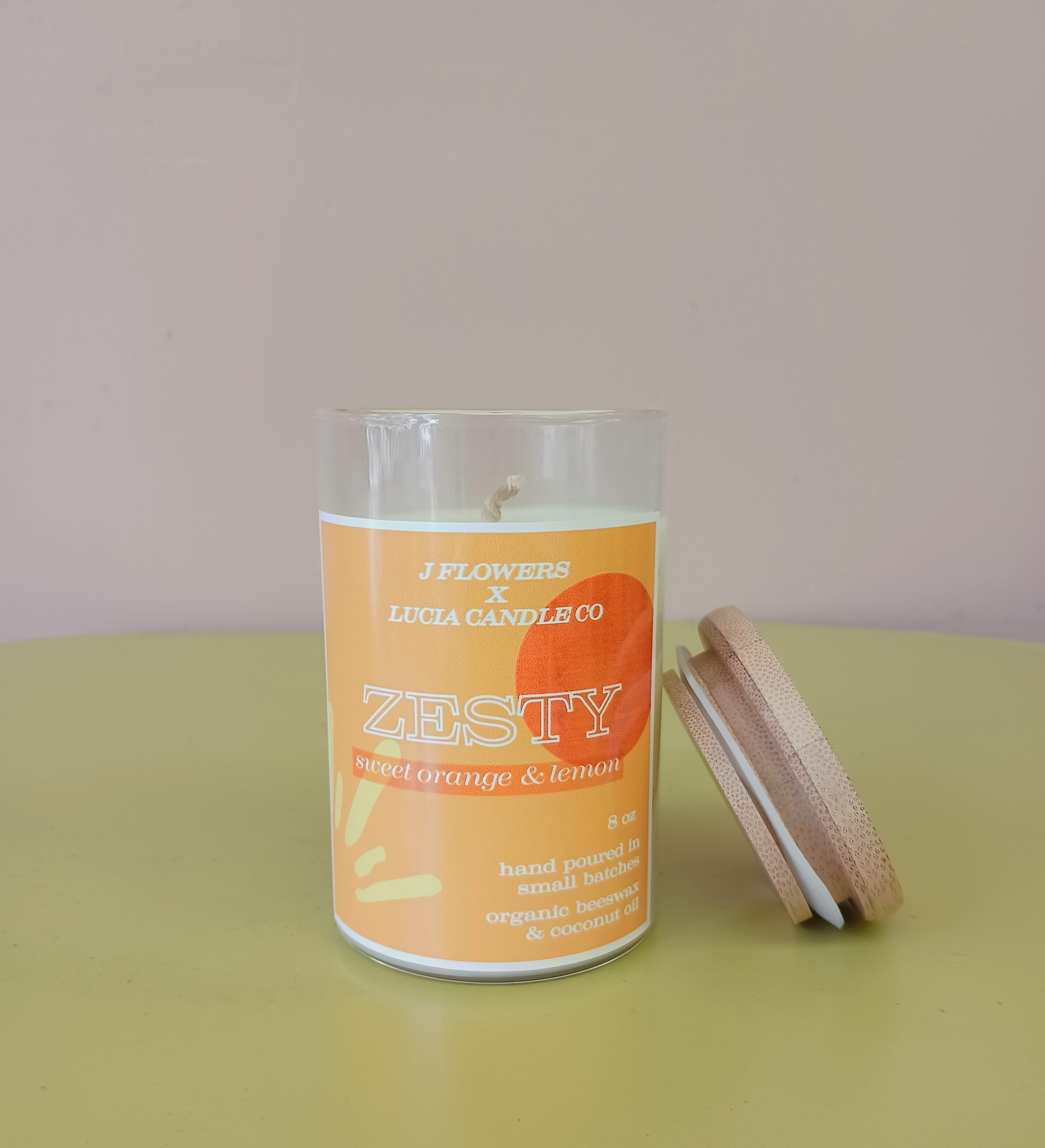 Orange scented candle in a glass jar with a wooden lid