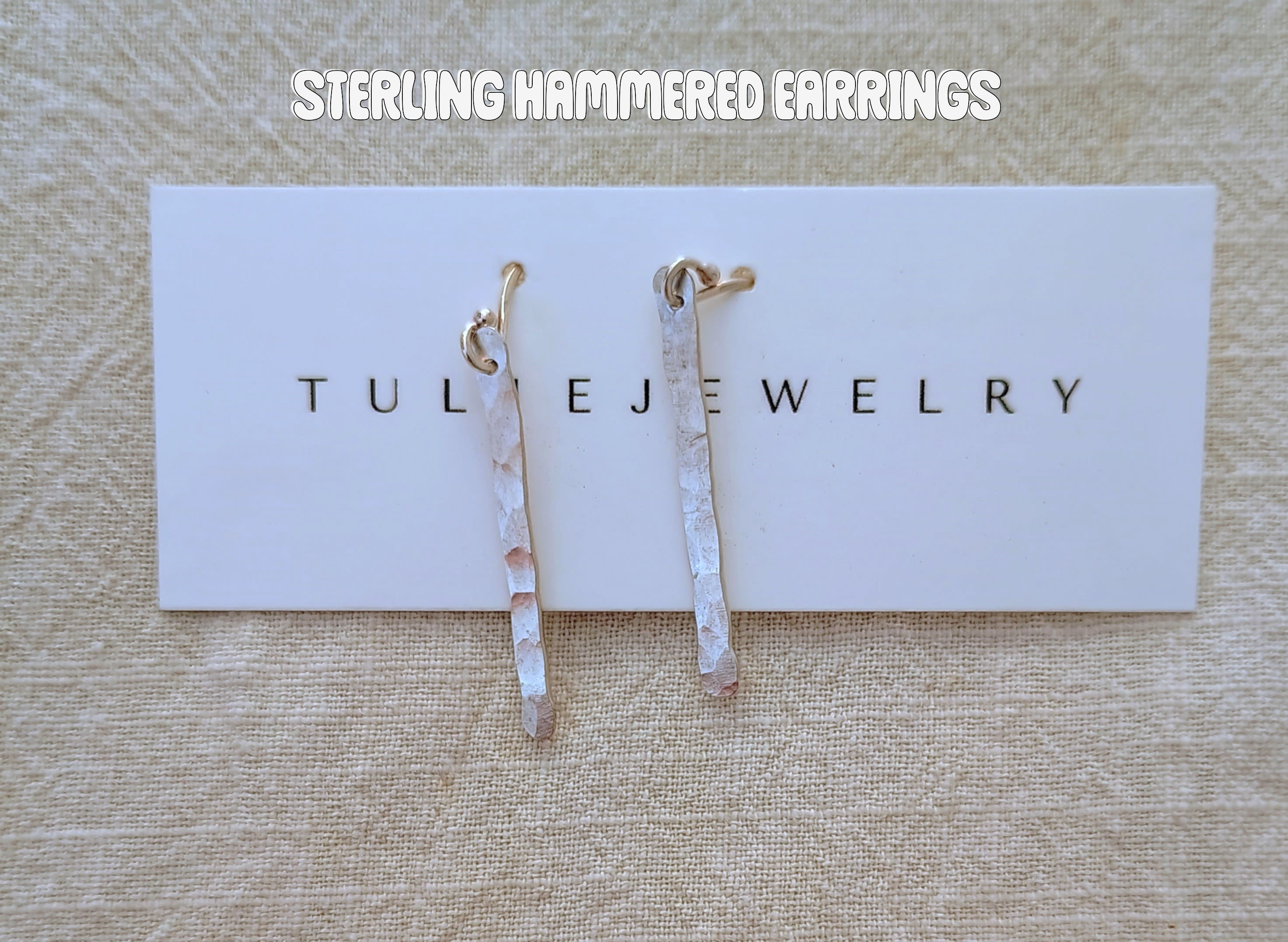 Pair of hammered silver drop earrings on a jewelry card