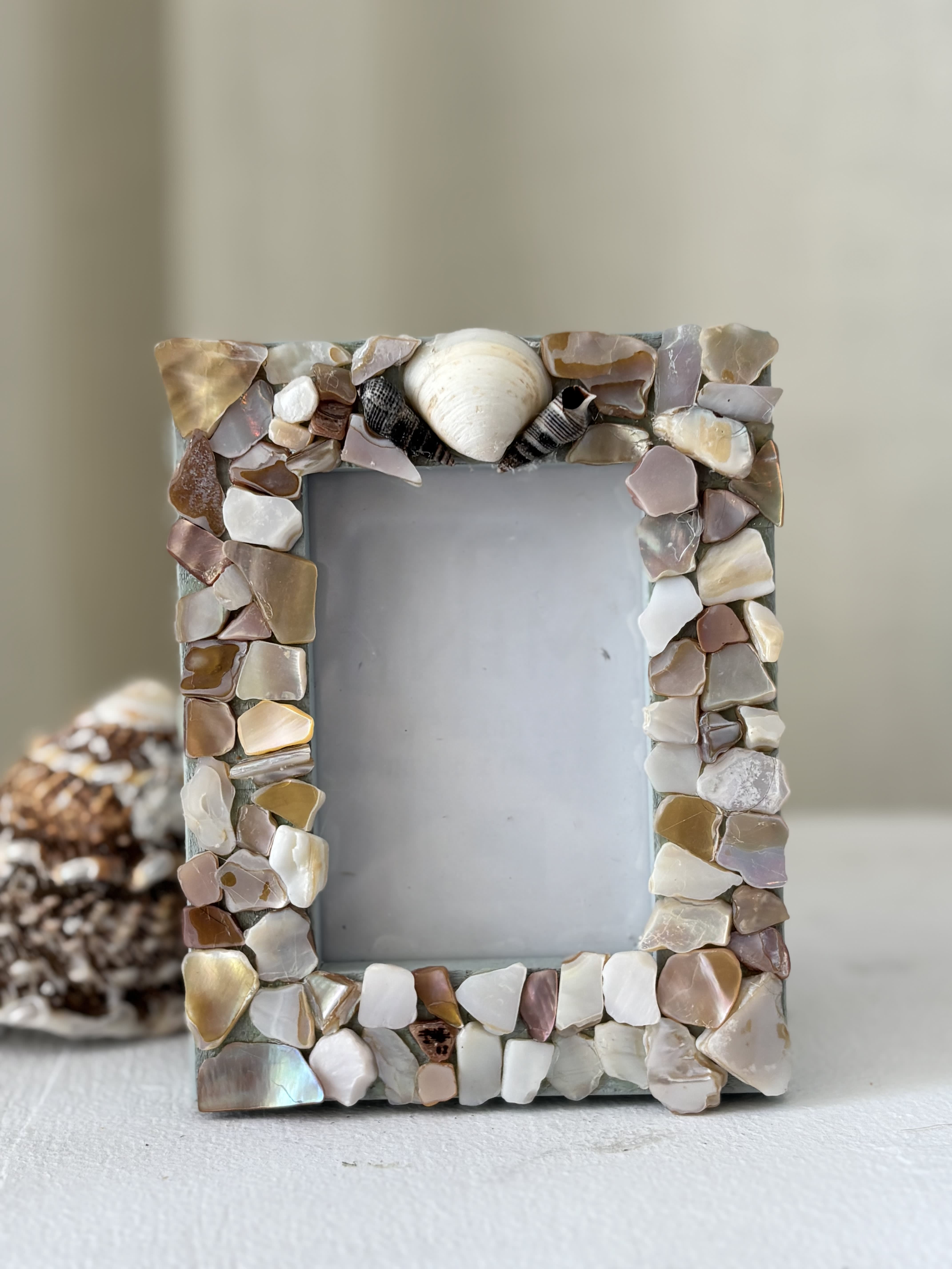 Decorative photo frame covered in shell pieces