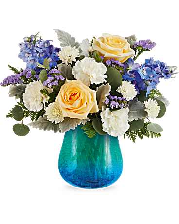 Golden Coast Bouquet - As bright and refreshing as a seaside breeze, the Golden Coast Bouquet shines with sunny yellow roses and cool blue blooms, artfully arranged in a turquoise glass vase with a crackled design and soft gradient finish. Golden Coast Bouquet includes yellow roses, white carnations, blue delphinium, white button spray chrysanthemums, purple sinuata statice, dusty miller, silver dollar eucalyptus, and leatherleaf fern. Beautifully arranged in a Blue Hues Vase, a translucent turquoise glass vase with a crackled gradient finish. Approximately 14 1/2" W x 13" H