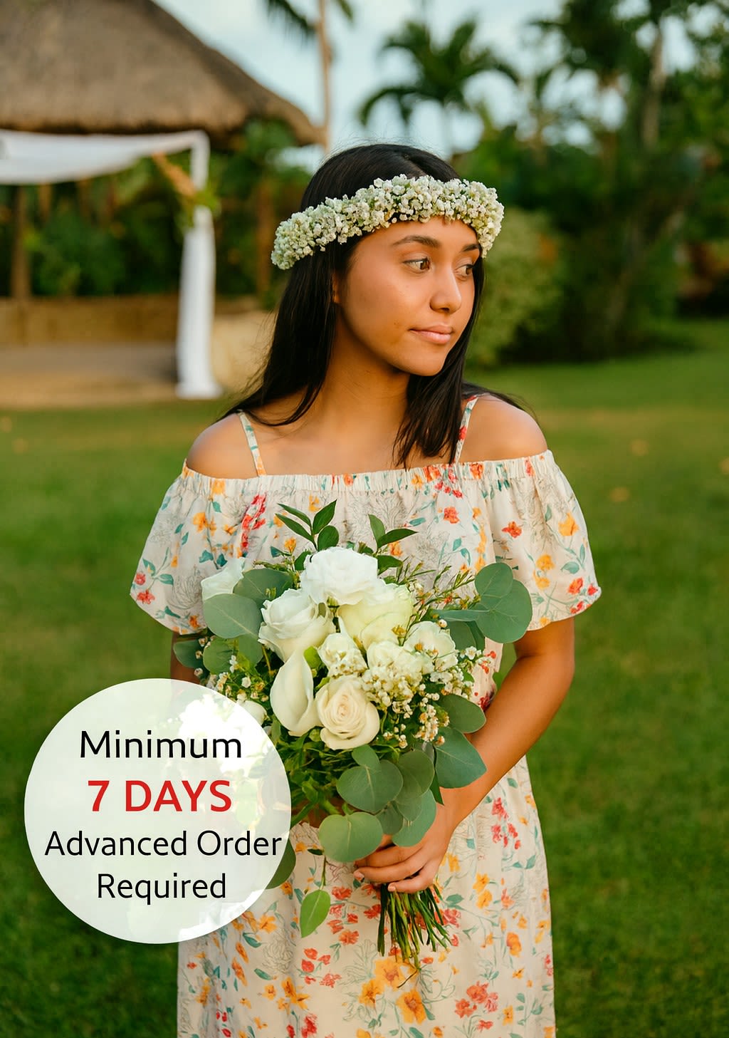 Young woman outdoors holding a white rose bouquet and wearing a white flower crown