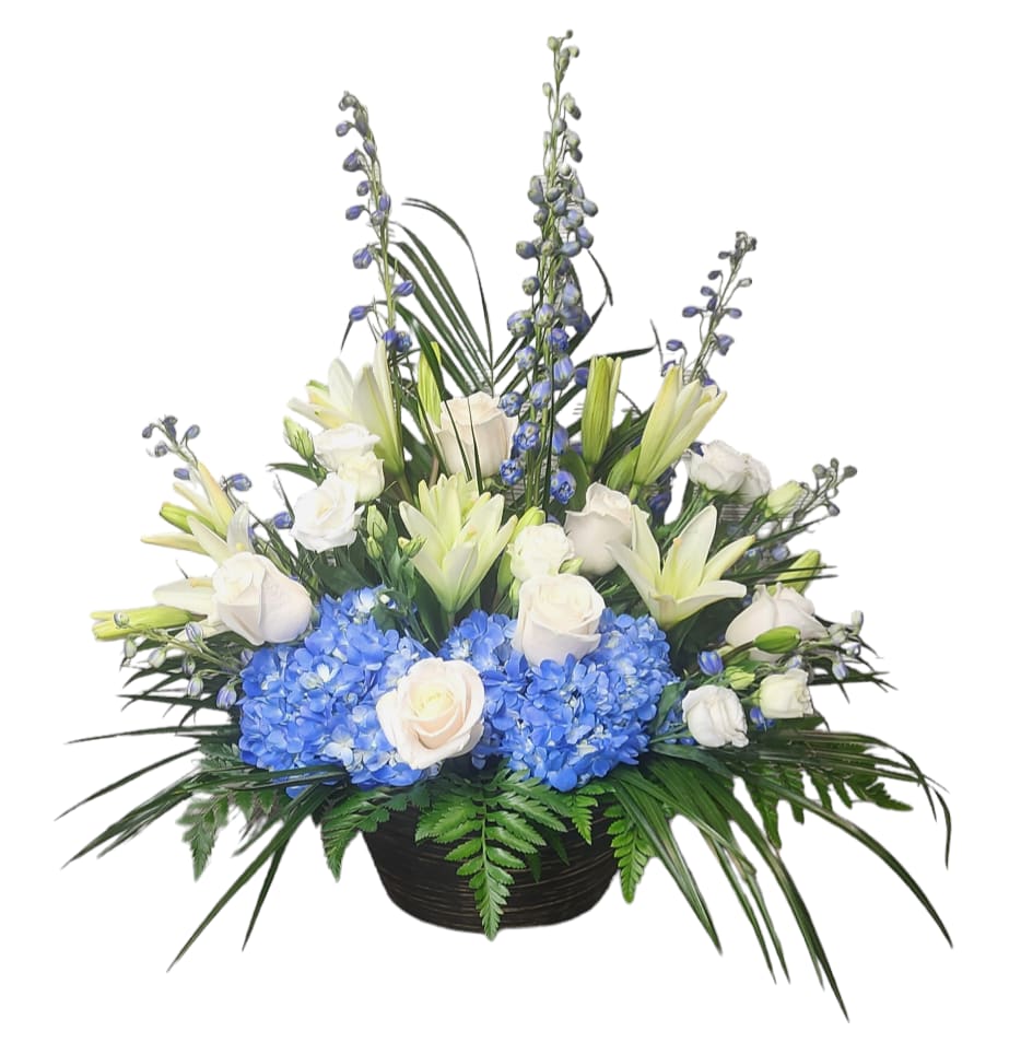 White roses and lilies with blue hydrangeas in a black basket
