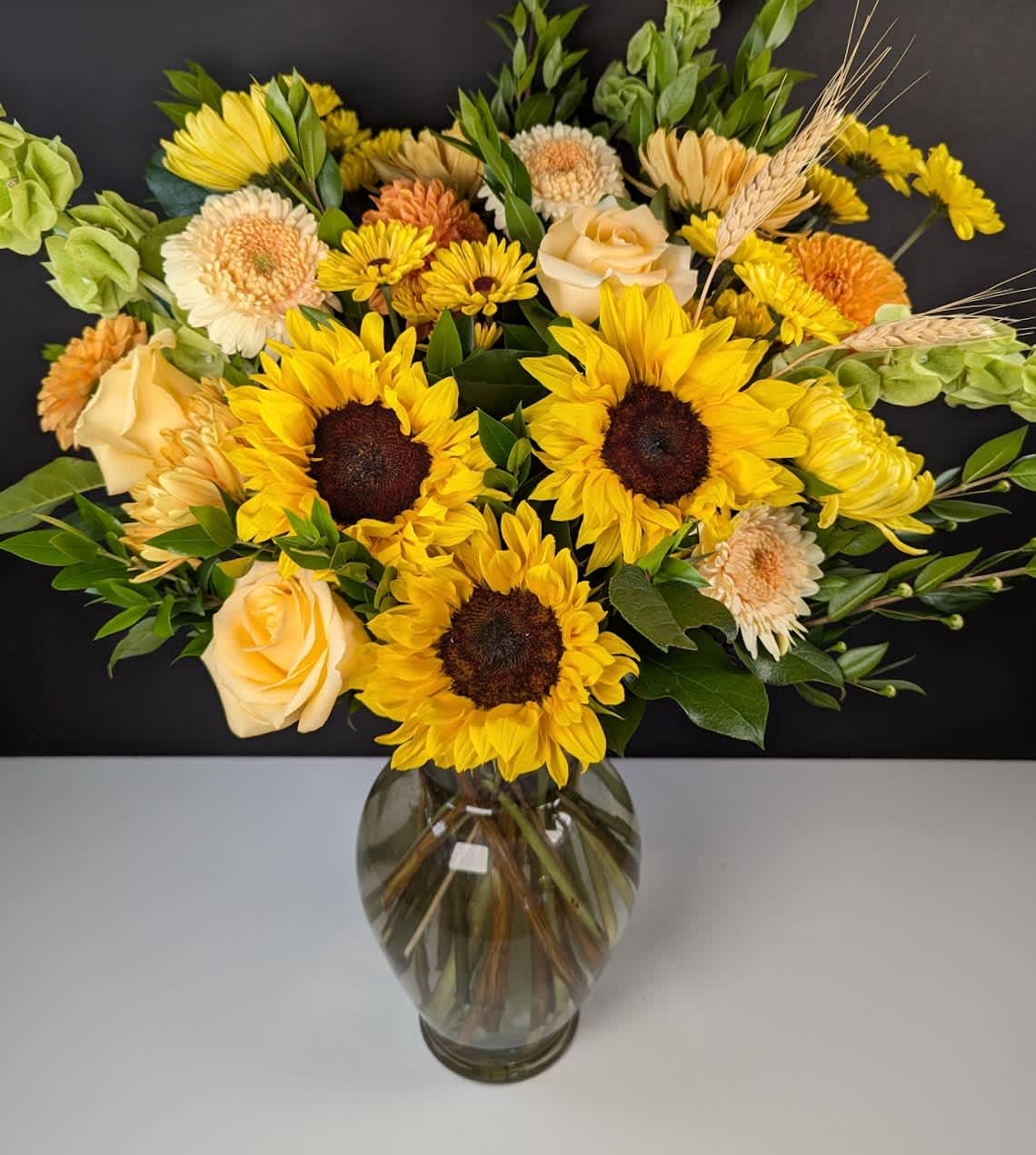 Sunflower and rose bouquet in a glass vase