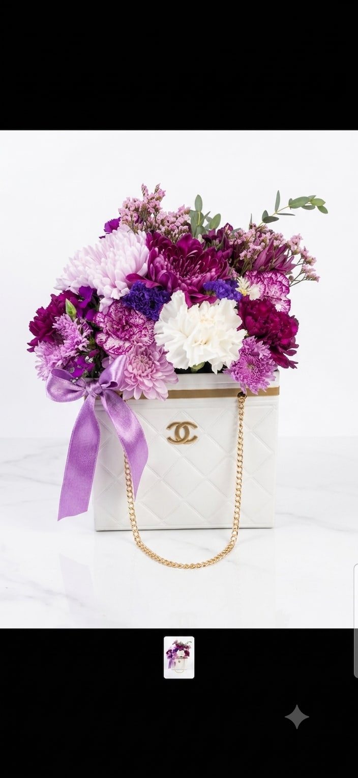 Purple and white flower arrangement in a white handbag-shaped box