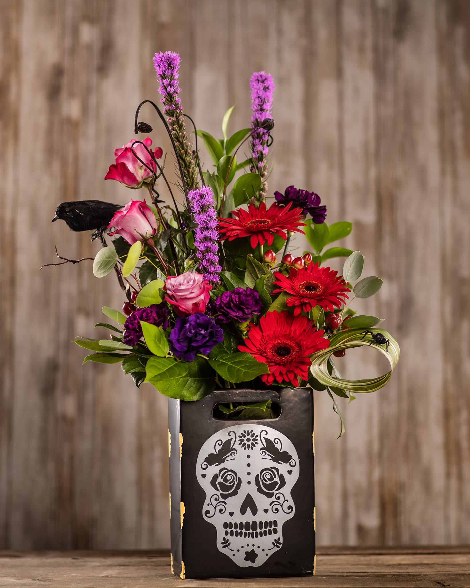 Bright mixed bouquet in a black skull-decorated box