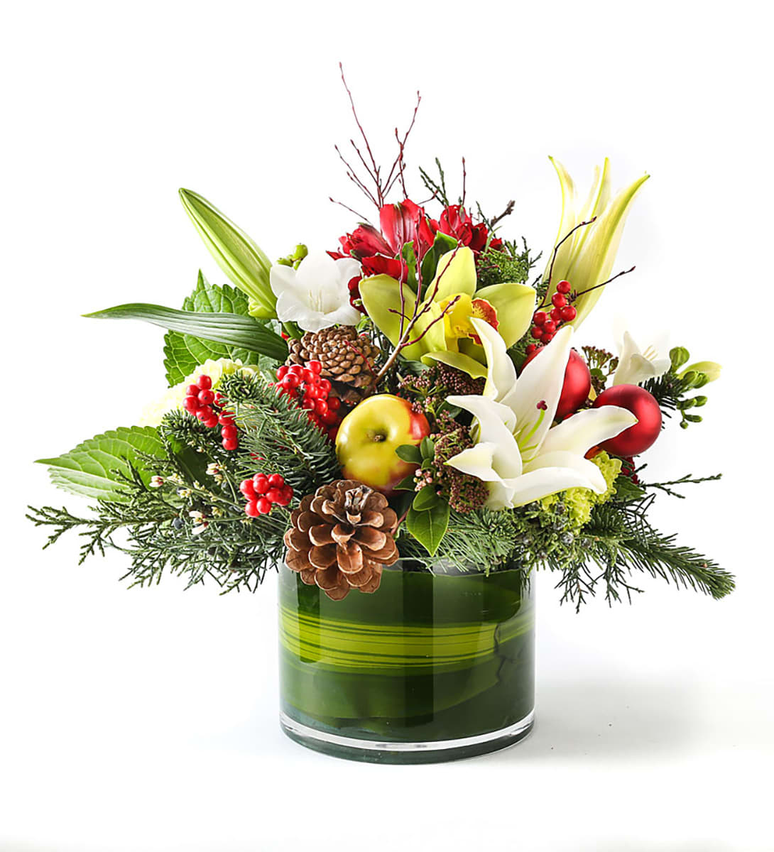 Holiday bouquet with lilies, apples, berries, and pinecones in a green glass vase