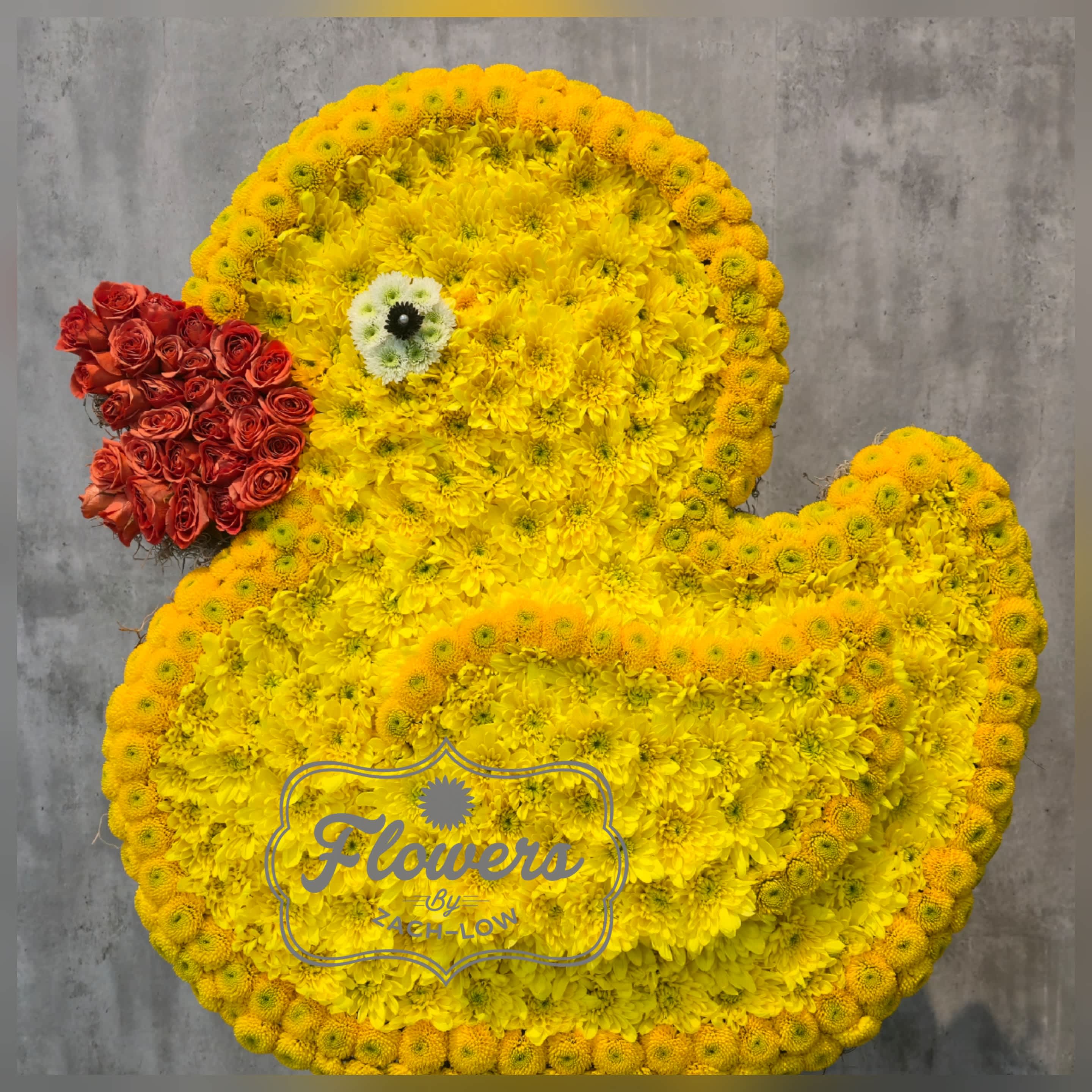 Duck-shaped floral arrangement made of yellow flowers with a red flower beak.