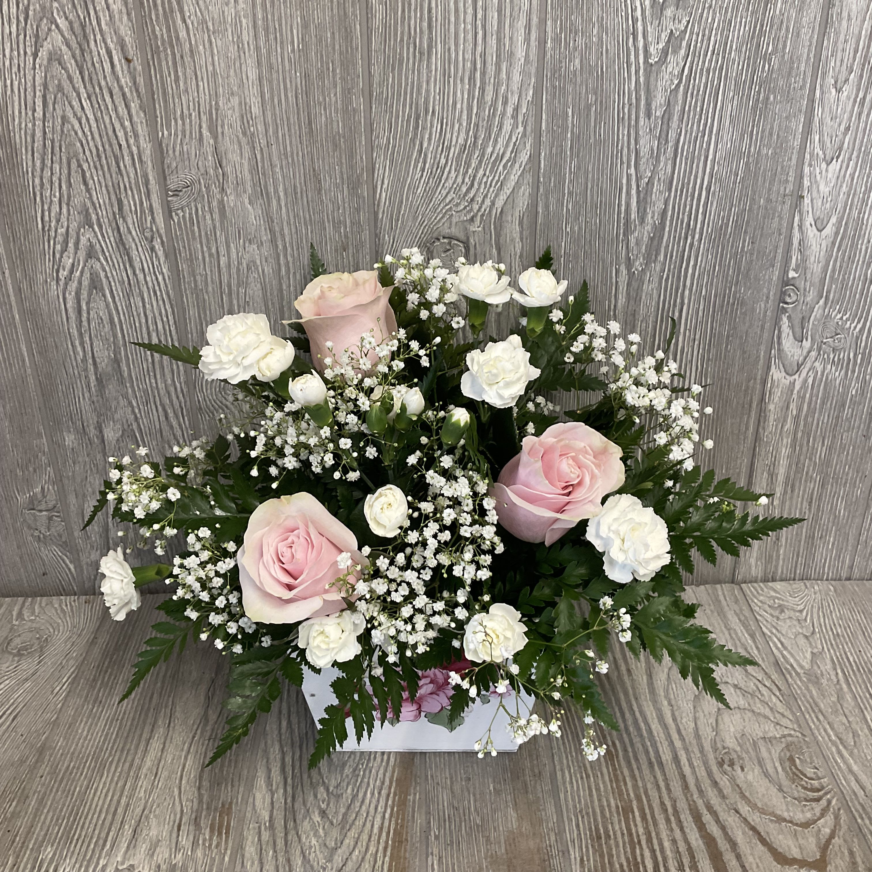 Pink and white rose arrangement in a white box