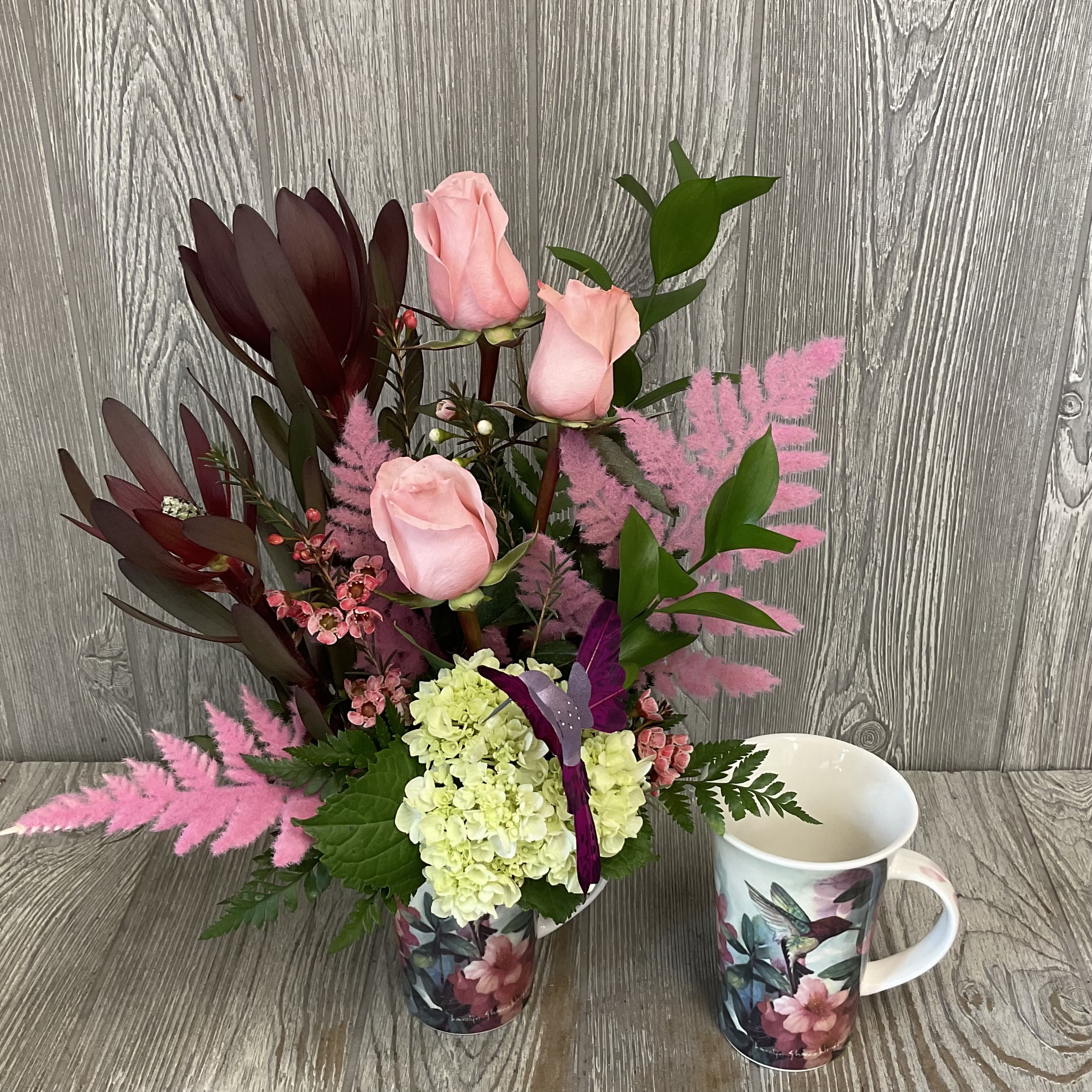 Hummingbird Mug - A modern style fresh cut flower arrangement, in a keepsake ceramic hummingbird mug. Flowers and colors may vary. 