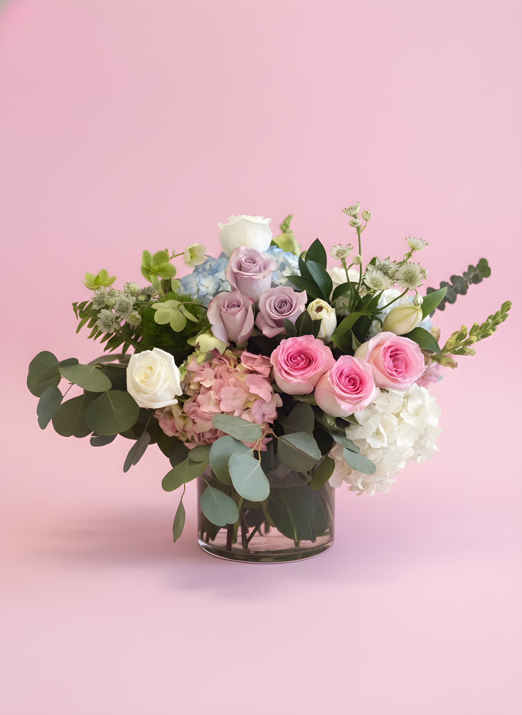 Pink and white roses with hydrangeas in a glass vase