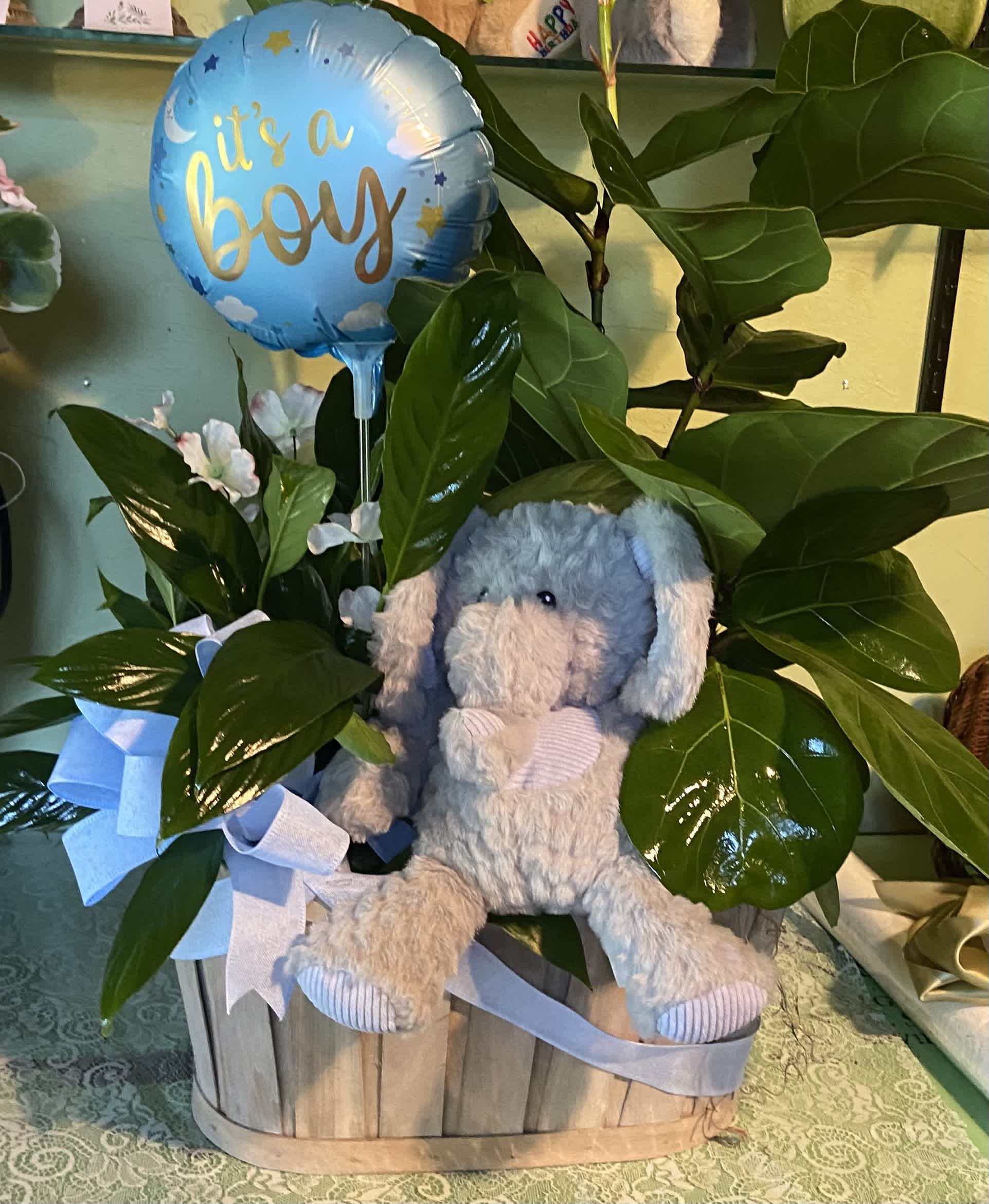 Blue boy balloon with a plush elephant in a wooden basket
