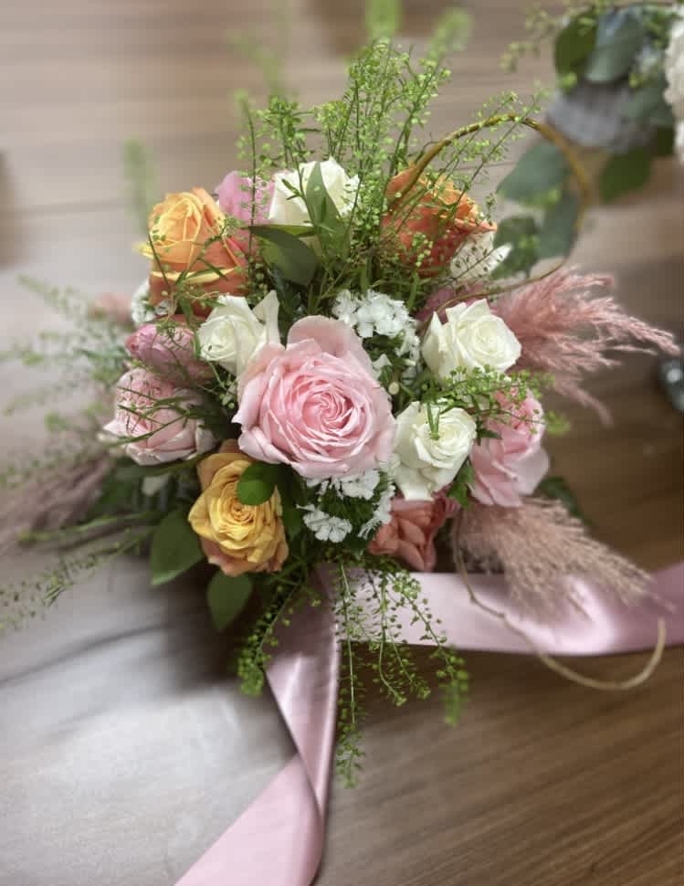 Bouquet of pink, white, and peach roses with ribbon wrap