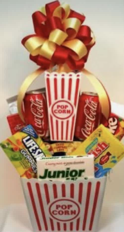 Popcorn bucket gift basket with candy and soda cans topped by a red-and-gold bow