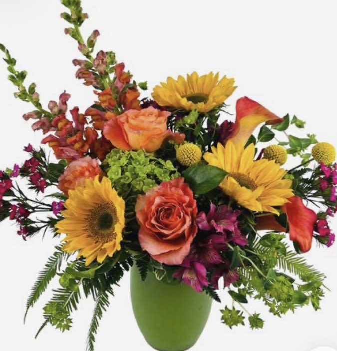 Mixed bouquet with sunflowers, roses, and calla lilies in a green vase