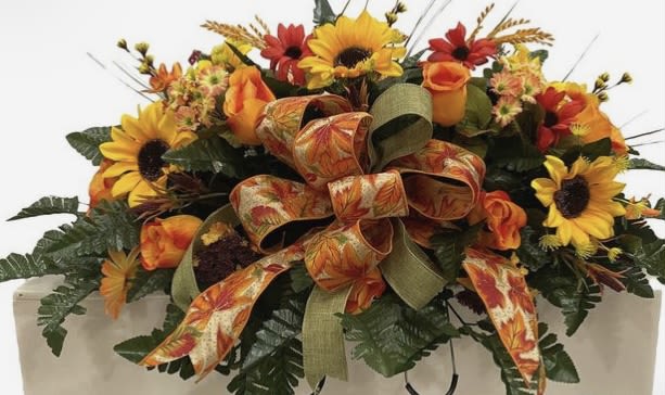 Autumn floral arrangement with sunflowers, roses, and ribbon accents