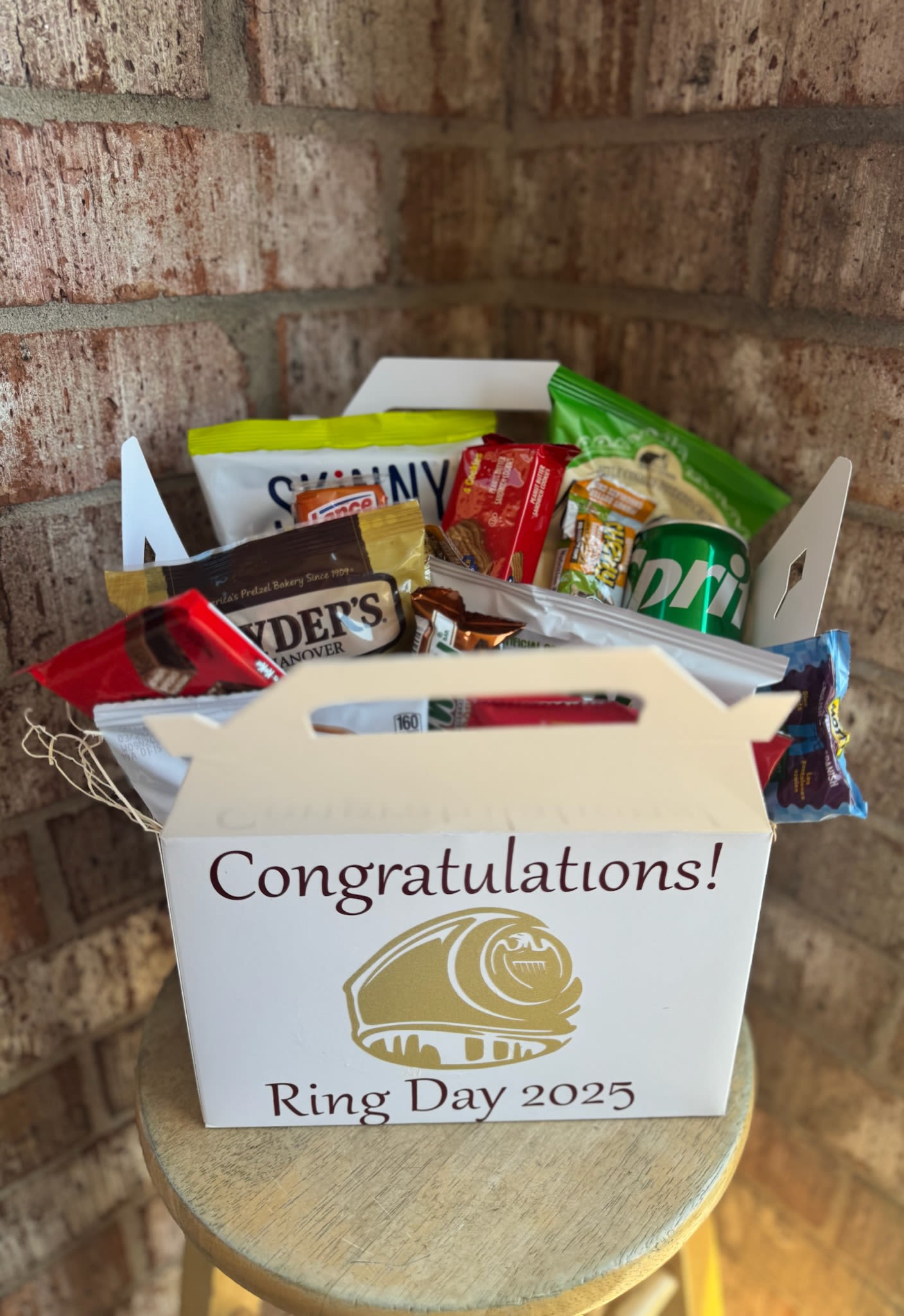 Gift box filled with assorted snack packs and a soda can