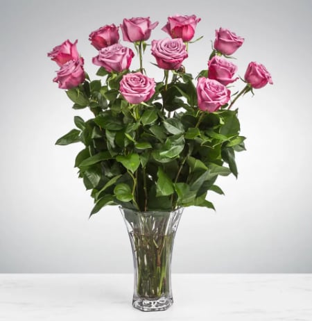 Dozen Long Stemmed Lavender Roses by BloomNation™ - This arrangement is the perfect "pick me up" to brighten someone's day. Dozen Long Stemmed Lavender Roses by BloomNation™ is the perfect gift for a birthday, get well, just because, and thank you.    Arrangement Details: 12 Long Stemmed Lavender Roses and Assorted Greenery APPROXIMATE DIMENSIONS: 25" H X 18" W