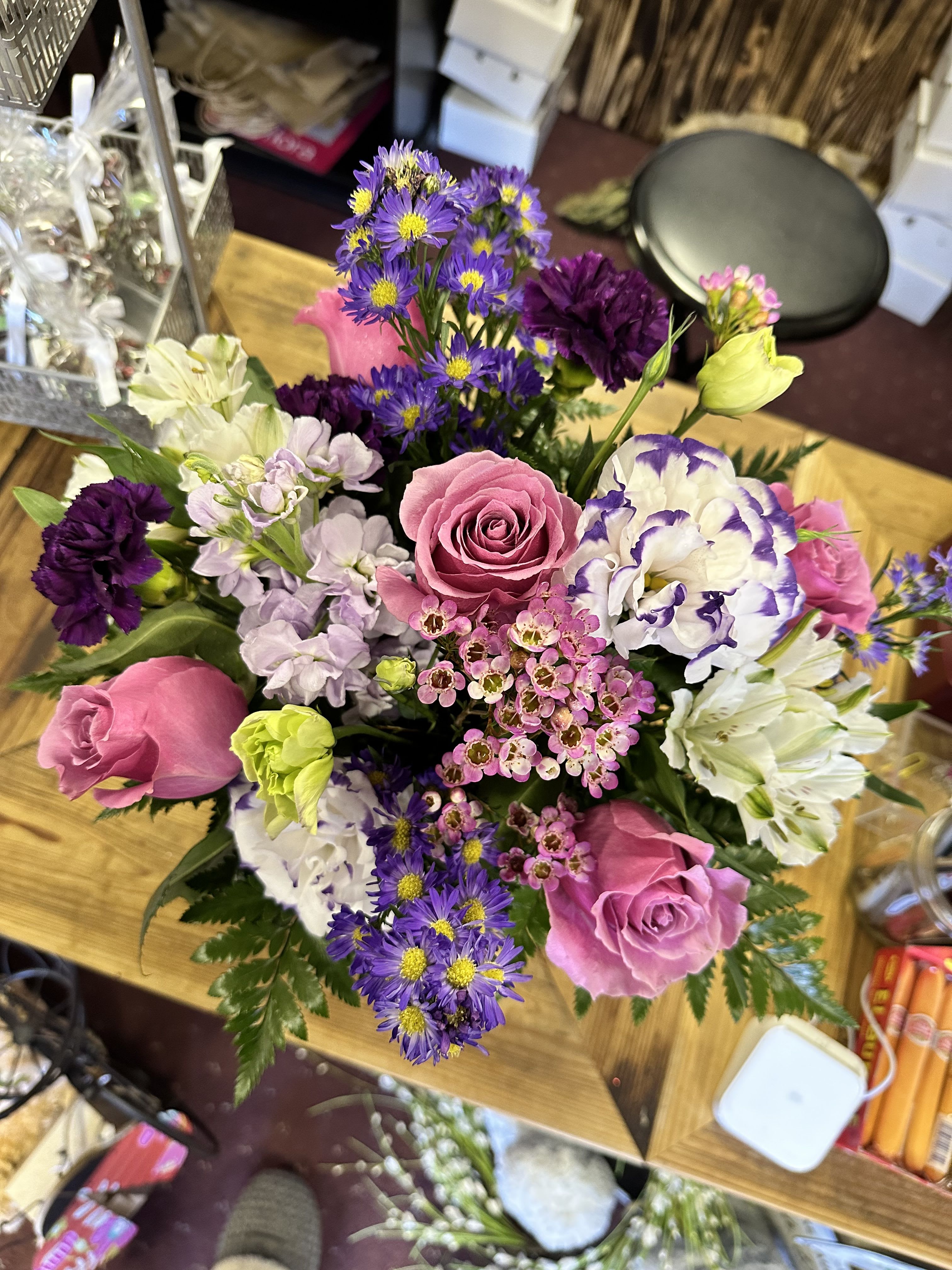 Mixed bouquet with pink roses, purple daisies, and white blooms