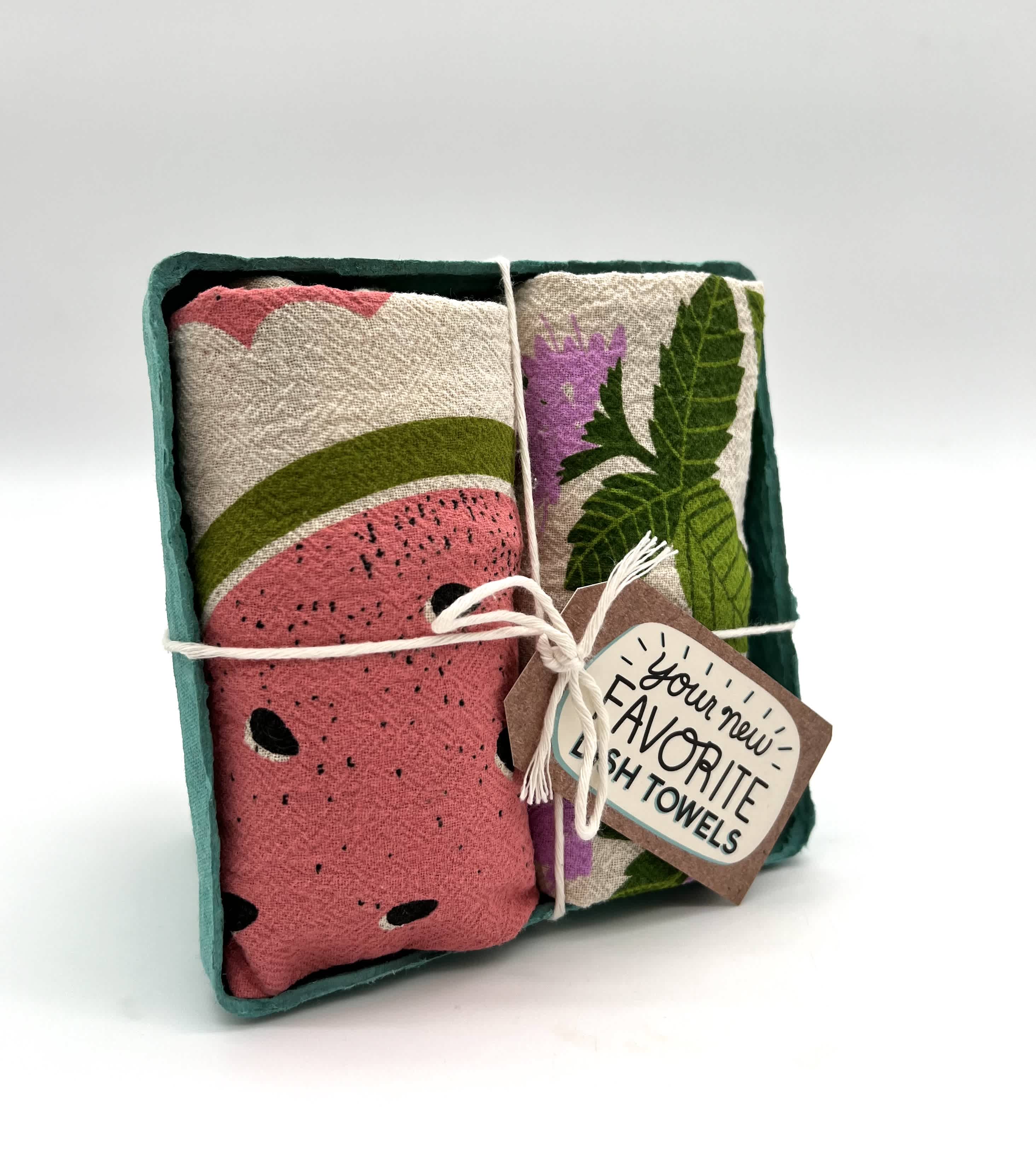 Set of patterned dish towels tied with string in a teal paper tray