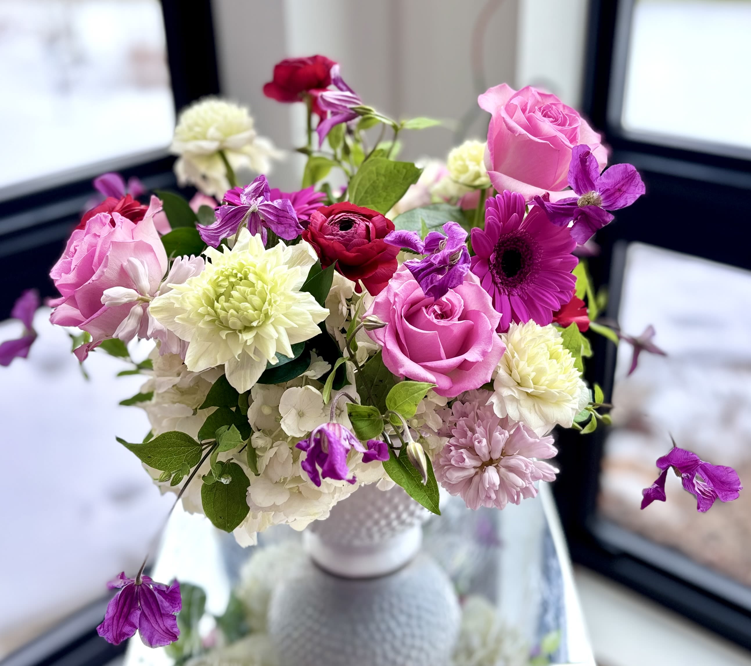 Floral Pearl - A lovely flower arrangement of premium blooms in shades of pink and white and some pop of fuchsia/purples in a white ceramic compote vase. We carefully select the most fresh premium flowers based on the availability, usually hydrangeas, roses, anemone, ranunculus, clematis, gerber and hyacinths. 