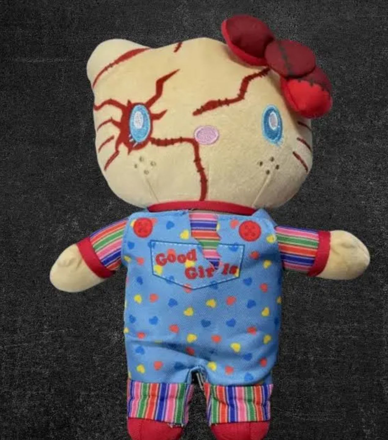 Plush doll with a cracked face and red flower accents