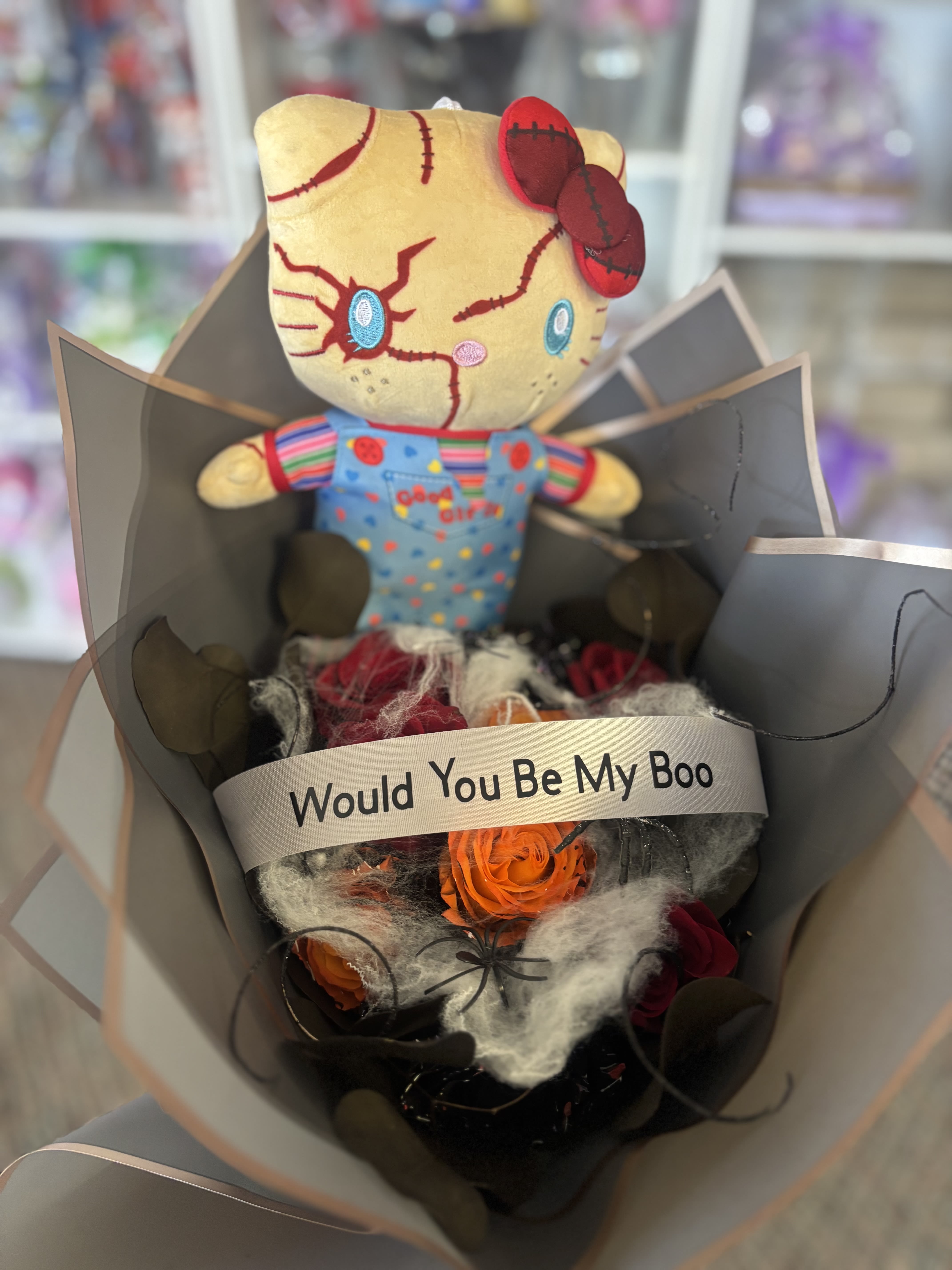 Bouquet with a plush doll and orange roses wrapped in gray paper