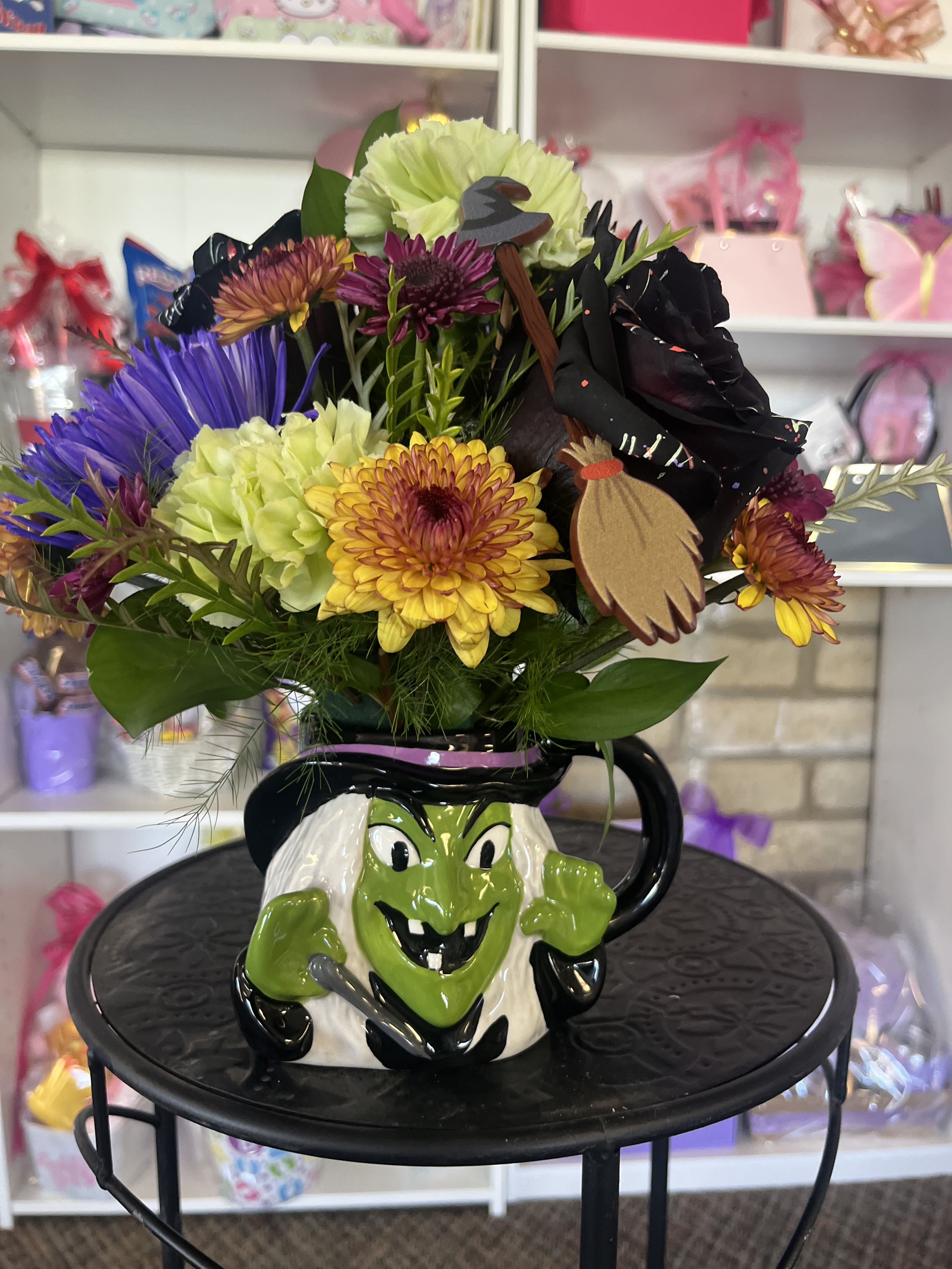 Colorful bouquet in a Halloween witch mug with a decorative witch face