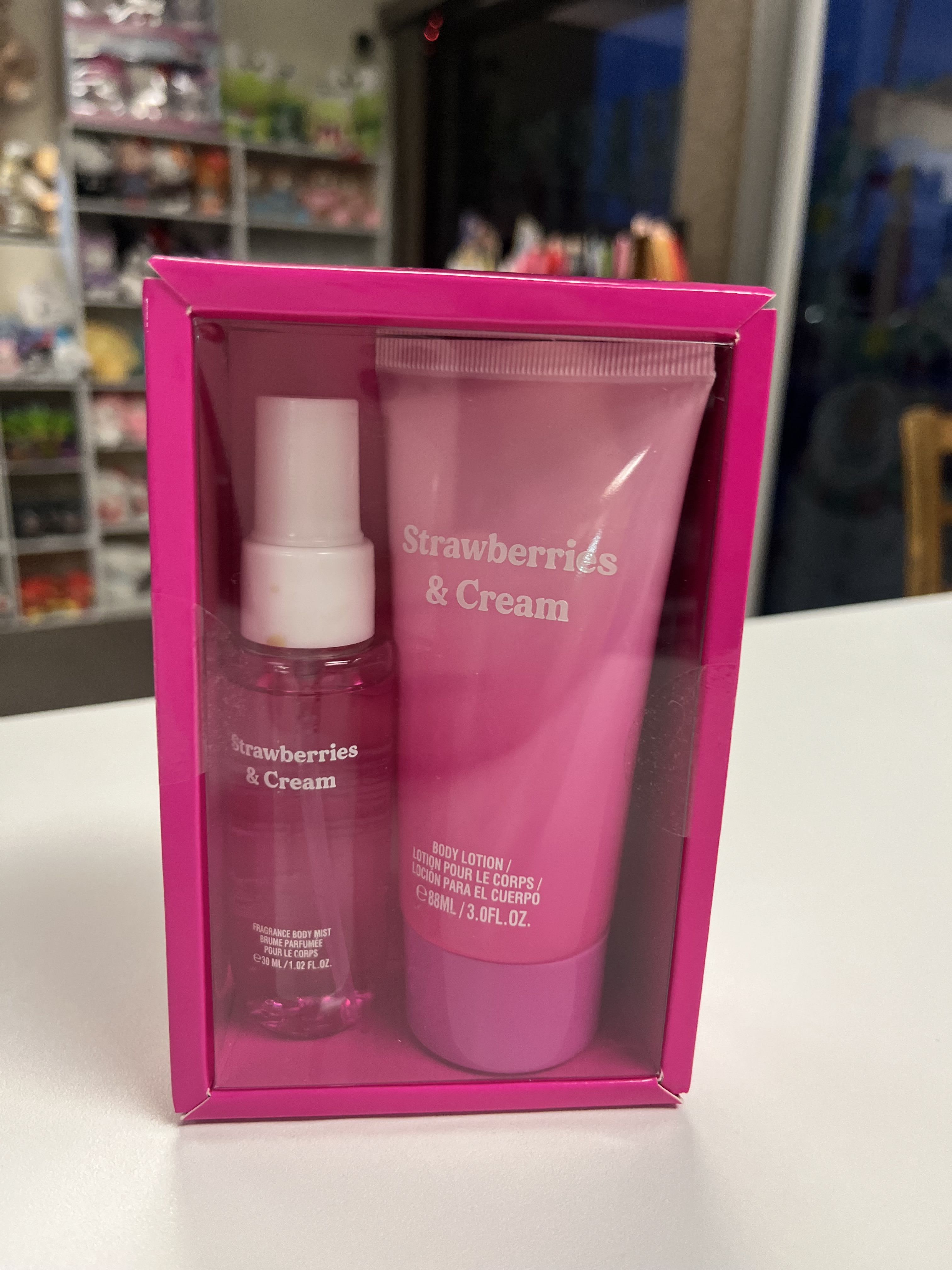 Pink gift set with body mist and lotion labeled Strawberries &amp; Cream
