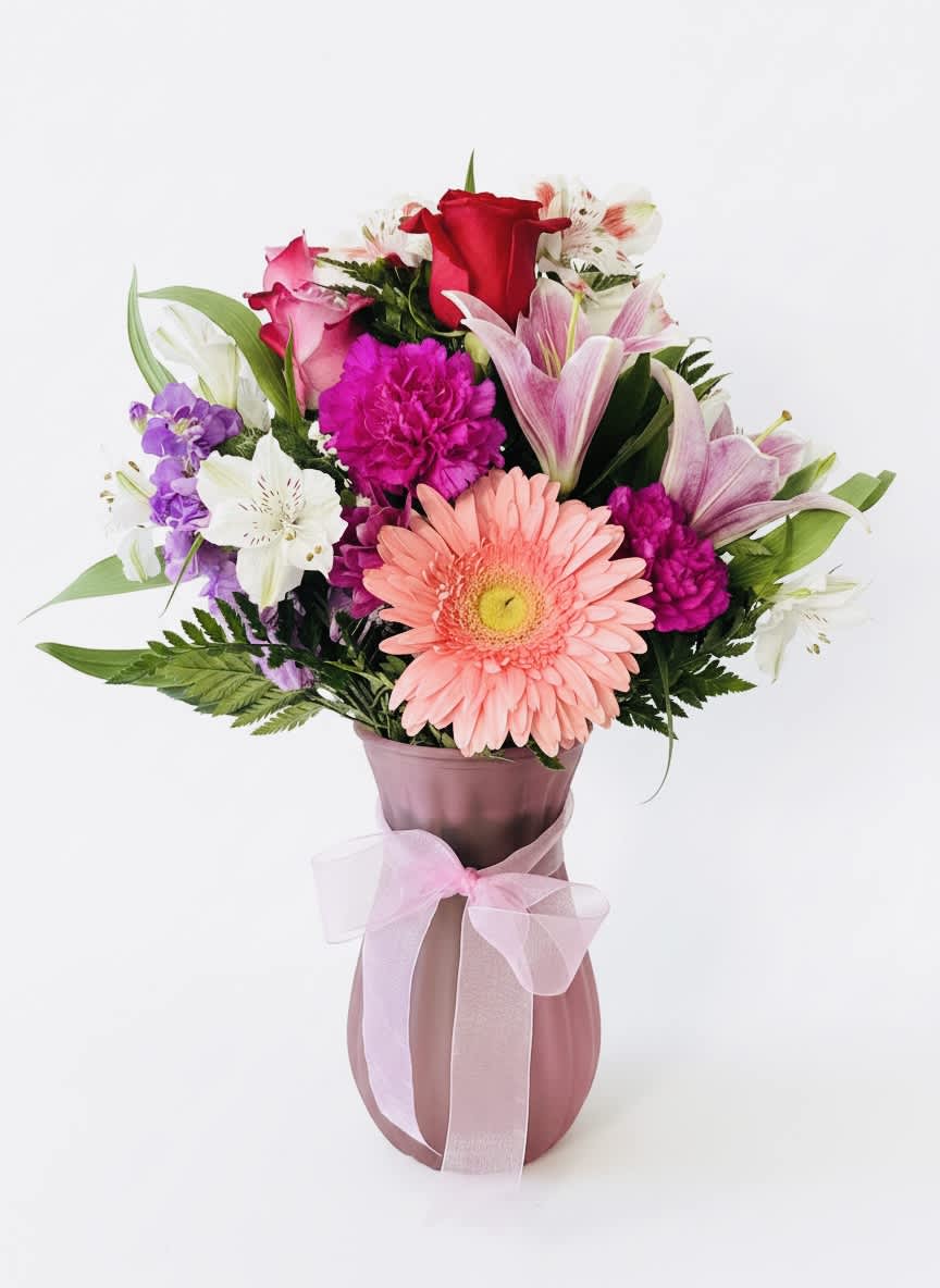 Mixed bouquet in a pink vase with a ribbon bow