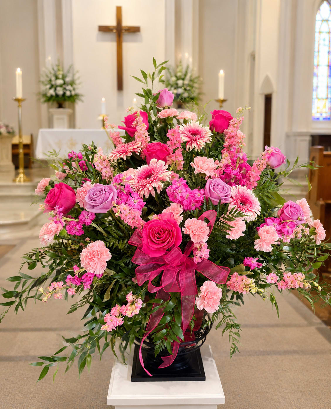 Large pink and lavender floral arrangement in a church setting