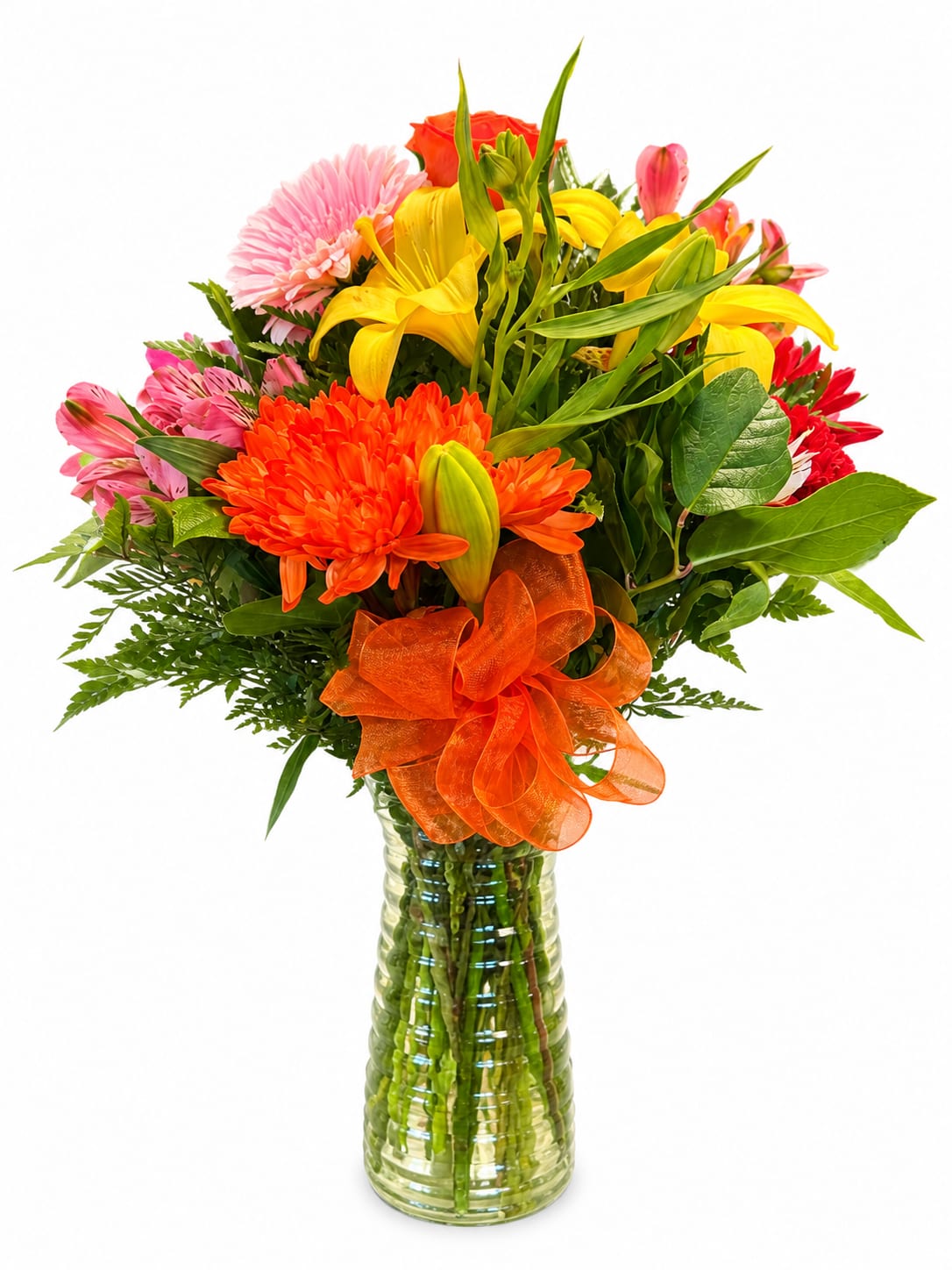 Mixed bouquet of yellow lilies, pink and orange flowers in a glass vase