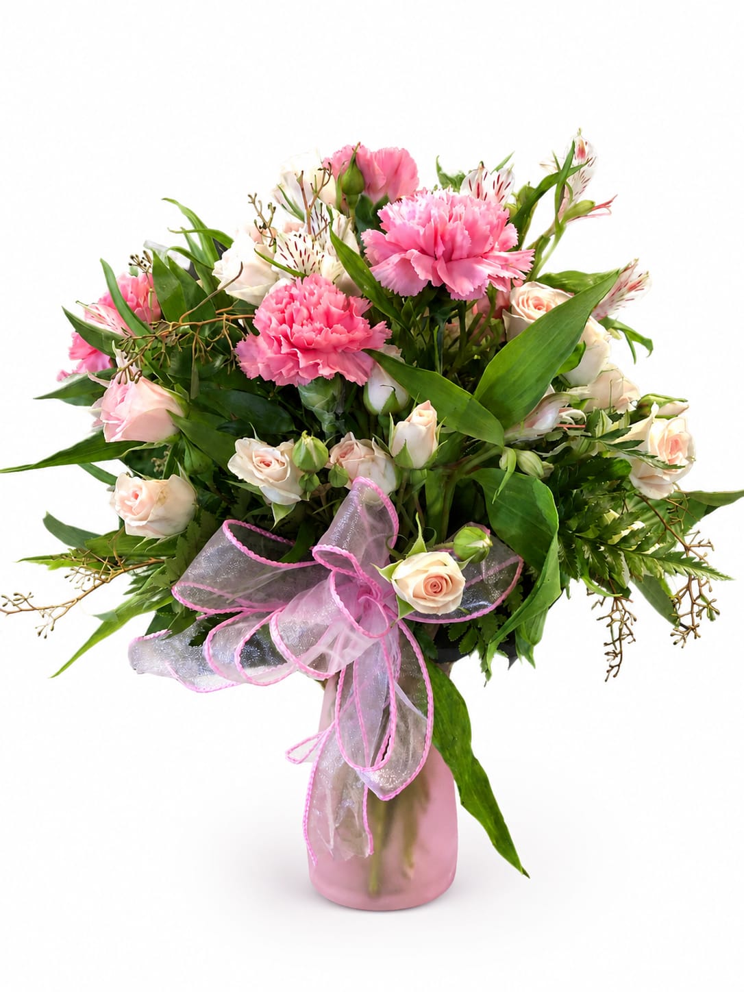Pink carnations and pale roses in a glass vase with a pink ribbon