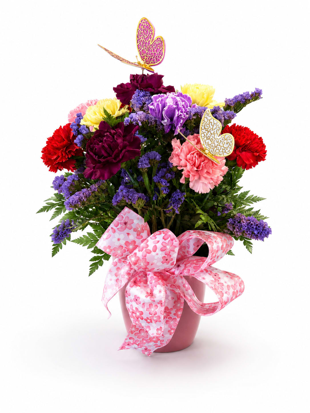 Colorful bouquet of carnations and purple filler flowers in a pink pot with a large ribbon