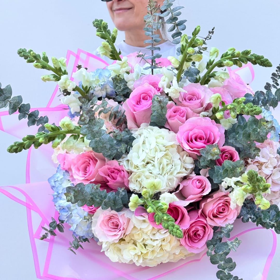 Pink roses and white hydrangeas in a bouquet with eucalyptus