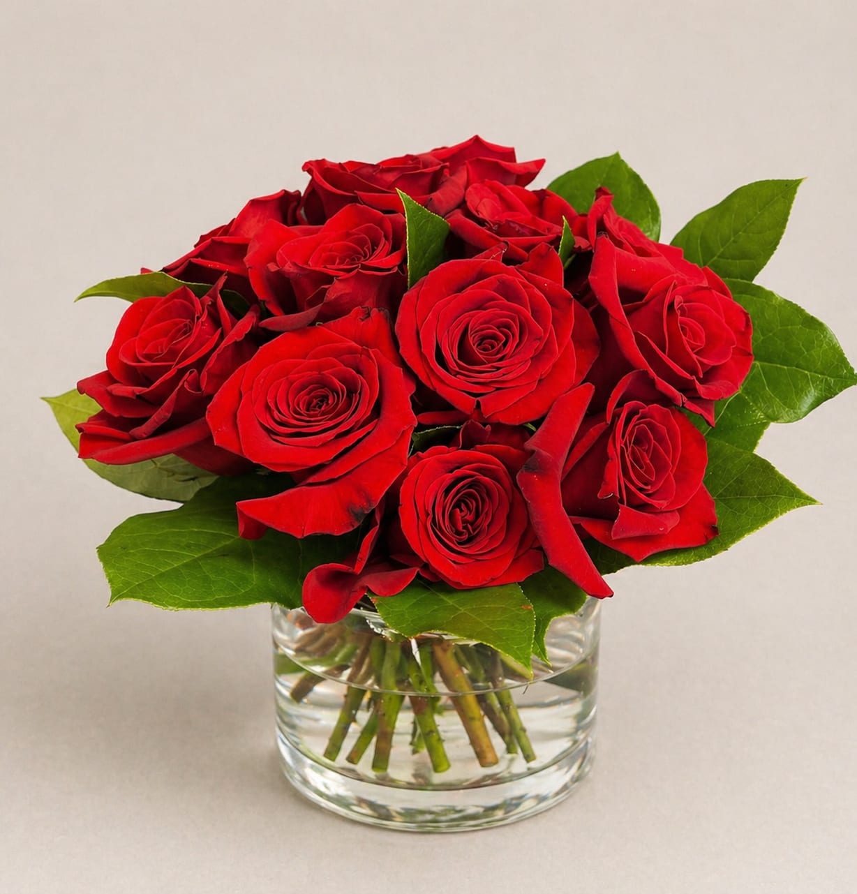 Short and Sweet - enjoy this modern twist on a dozen roses, cut short with fresh greens and wrapped with wire