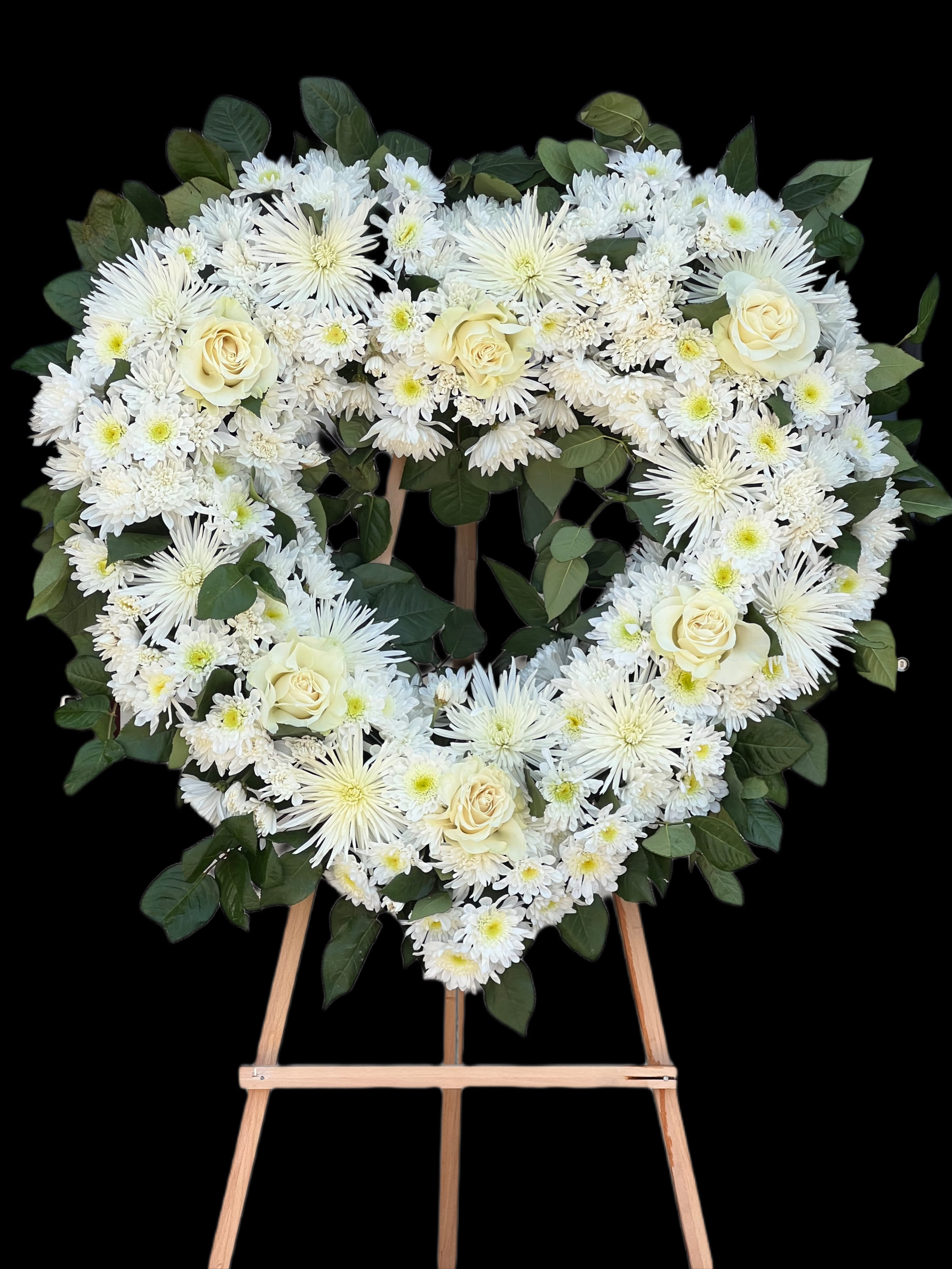 Heart-shaped white floral wreath on a wooden easel