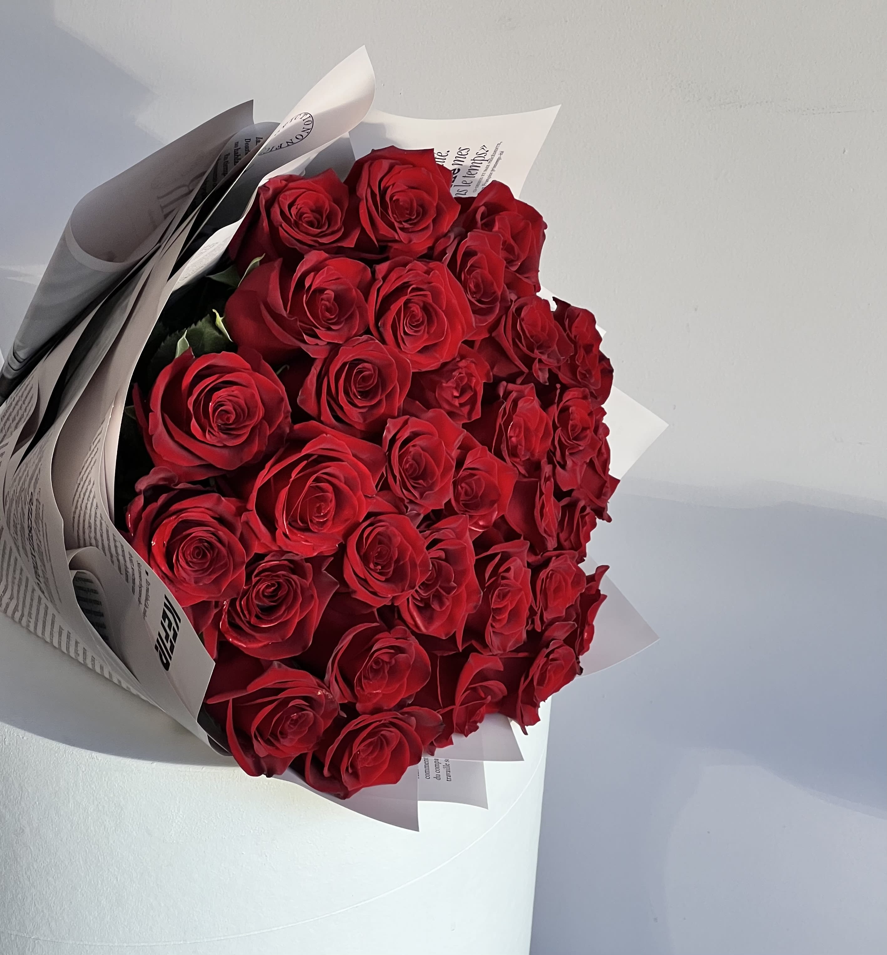 Bouquet of red roses wrapped in white paper