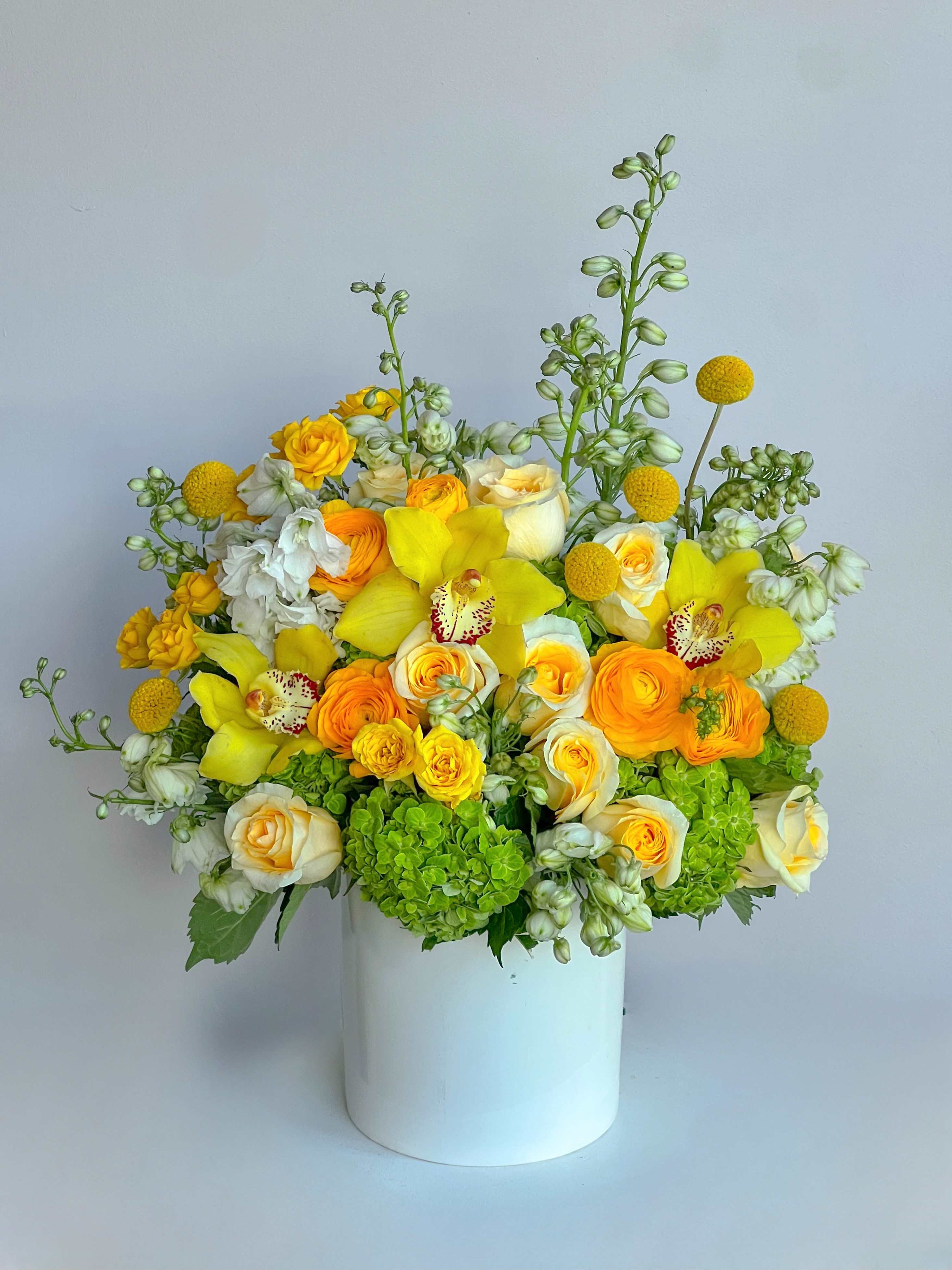 Yellow and white floral arrangement in a white vase