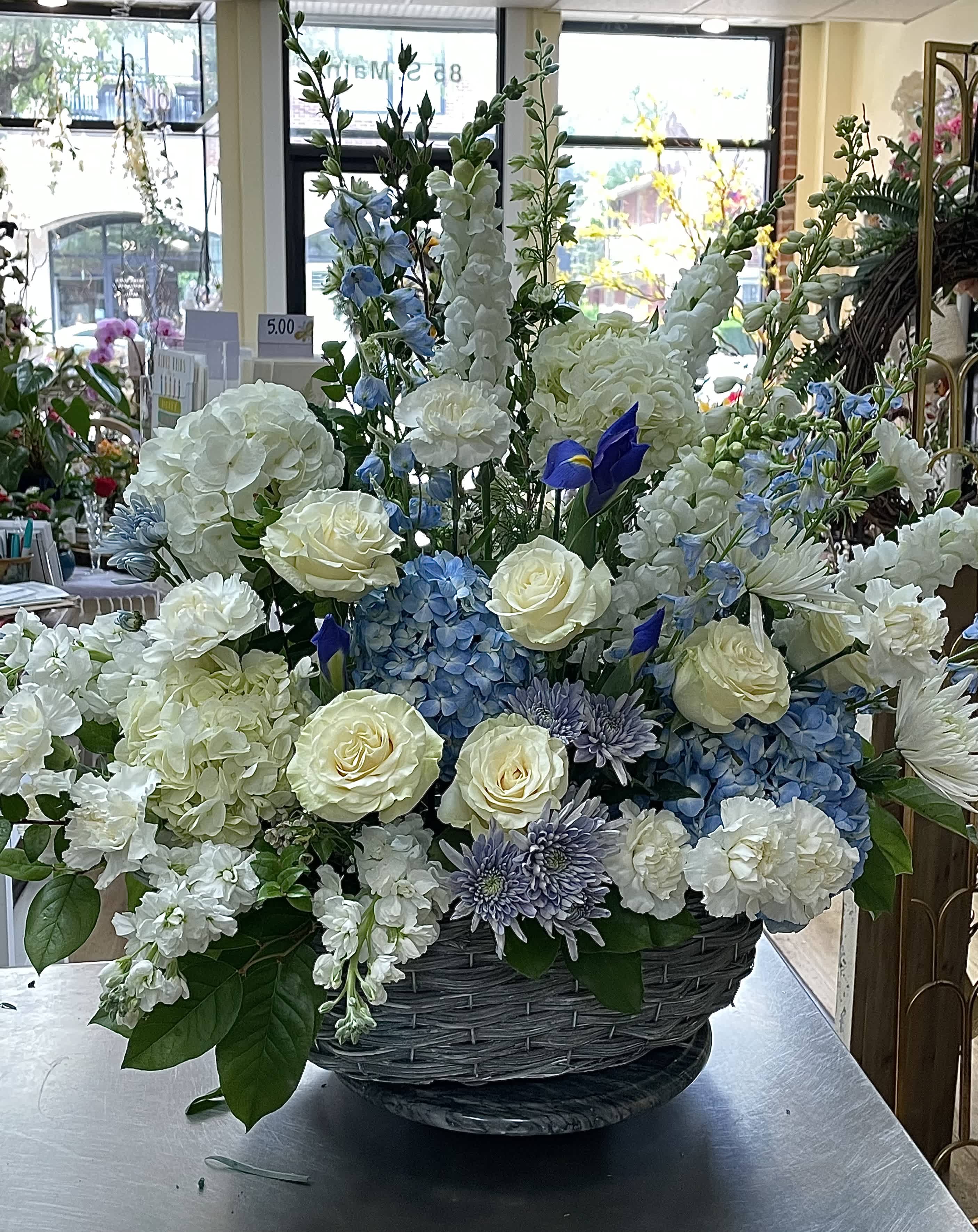 Large basket arrangement of white, blue, and lavender flowers