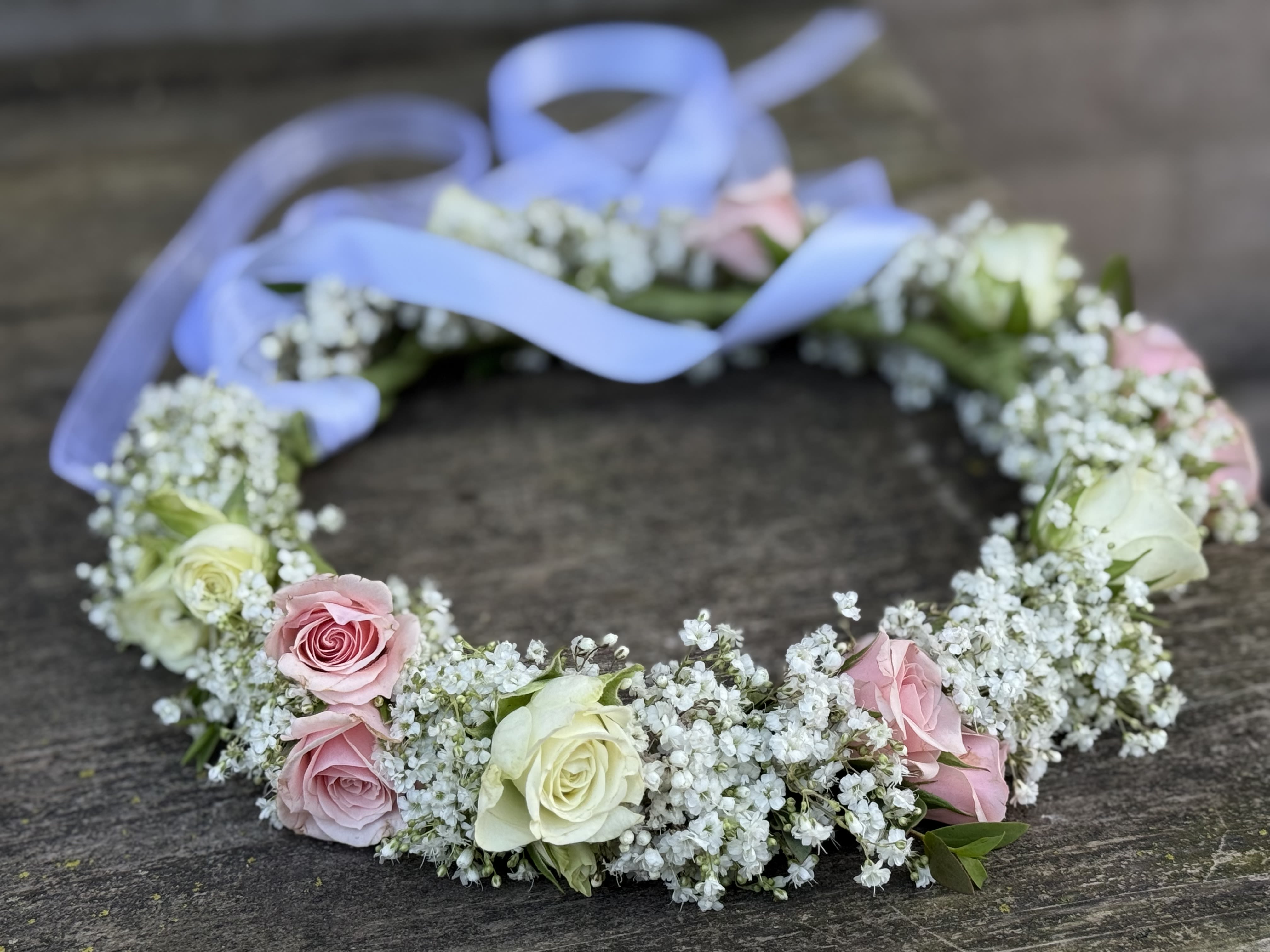 Floral crown of pink and white roses with a lavender ribbon