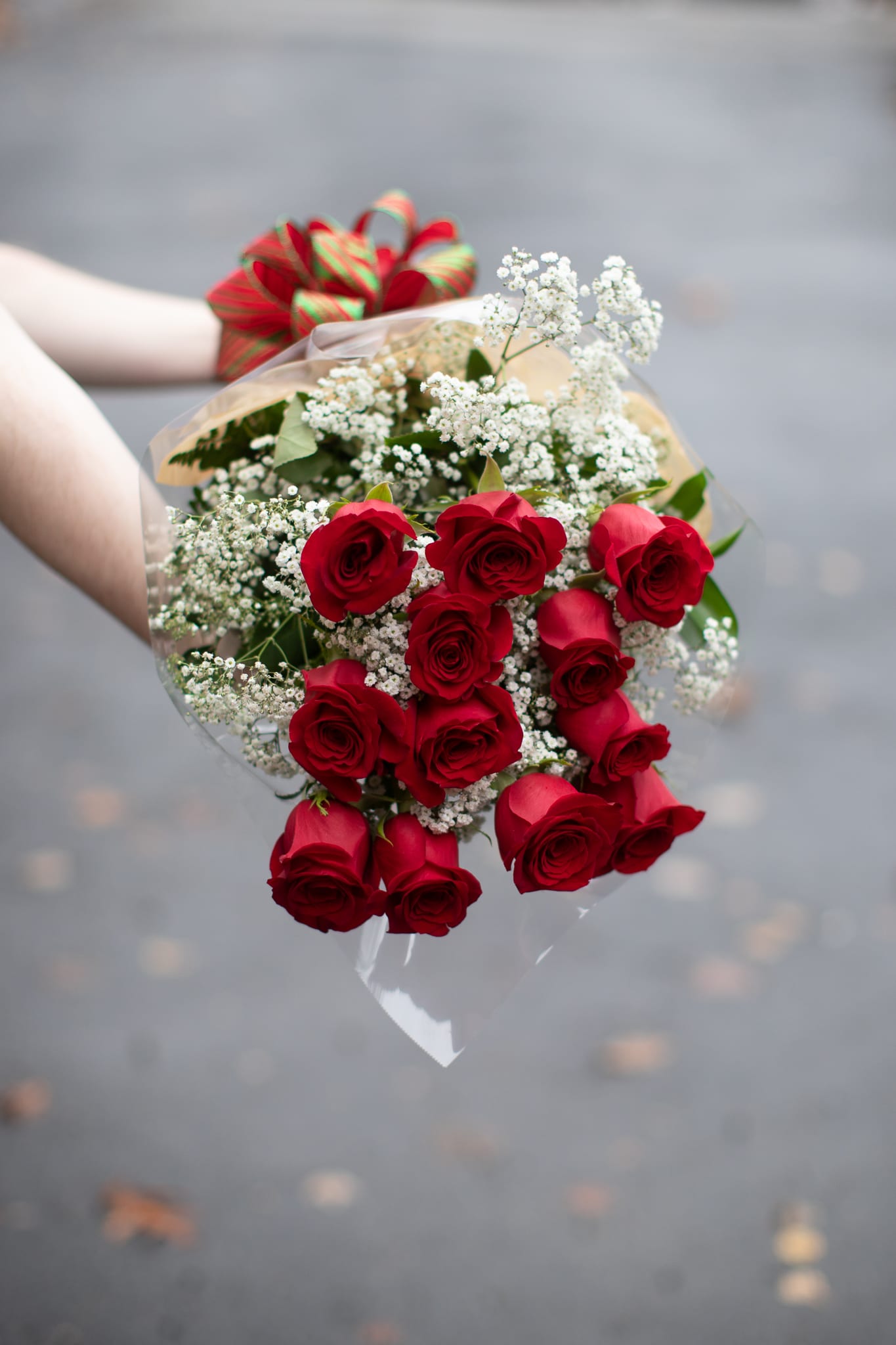 Bouquet of red roses with white baby's breath and a striped ribbon