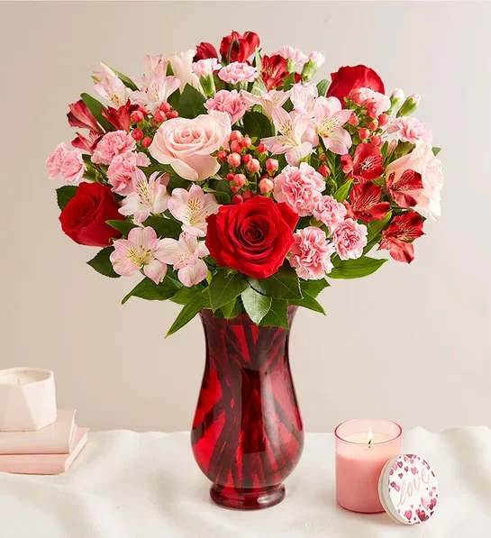 Bouquet of red and pink flowers in a red glass vase