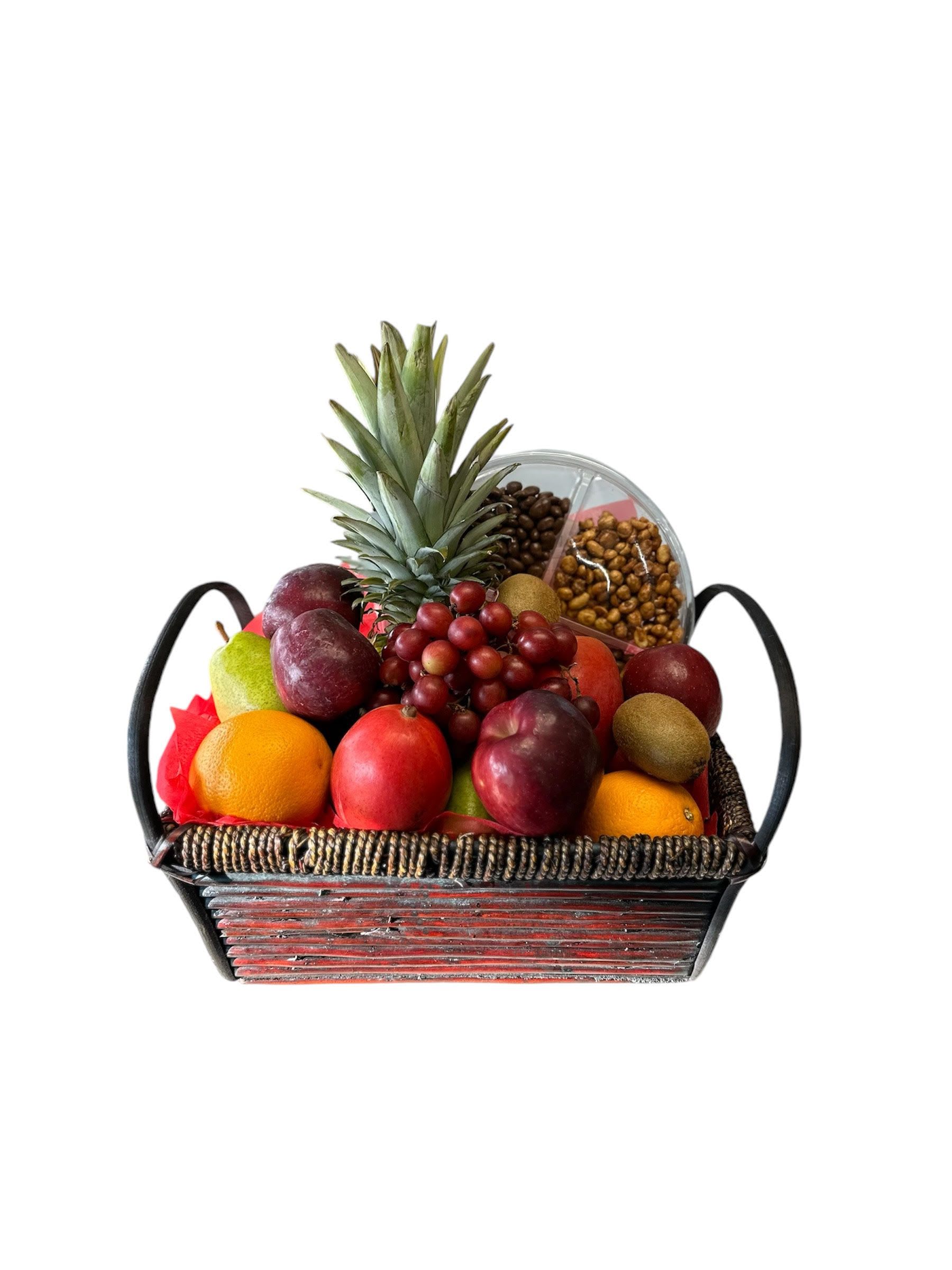 Fruit basket with pineapple, grapes, oranges, and assorted fruit in a woven tray