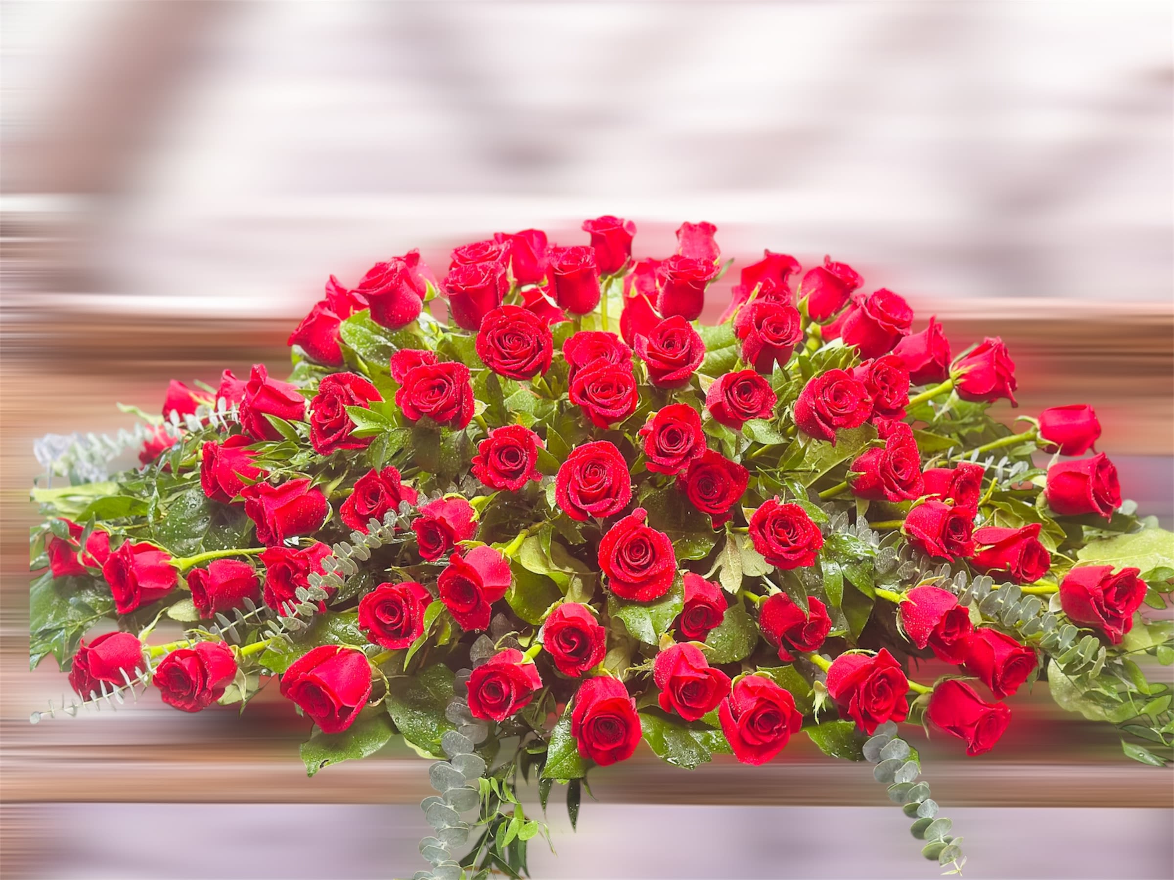 Large arrangement of red roses with greenery
