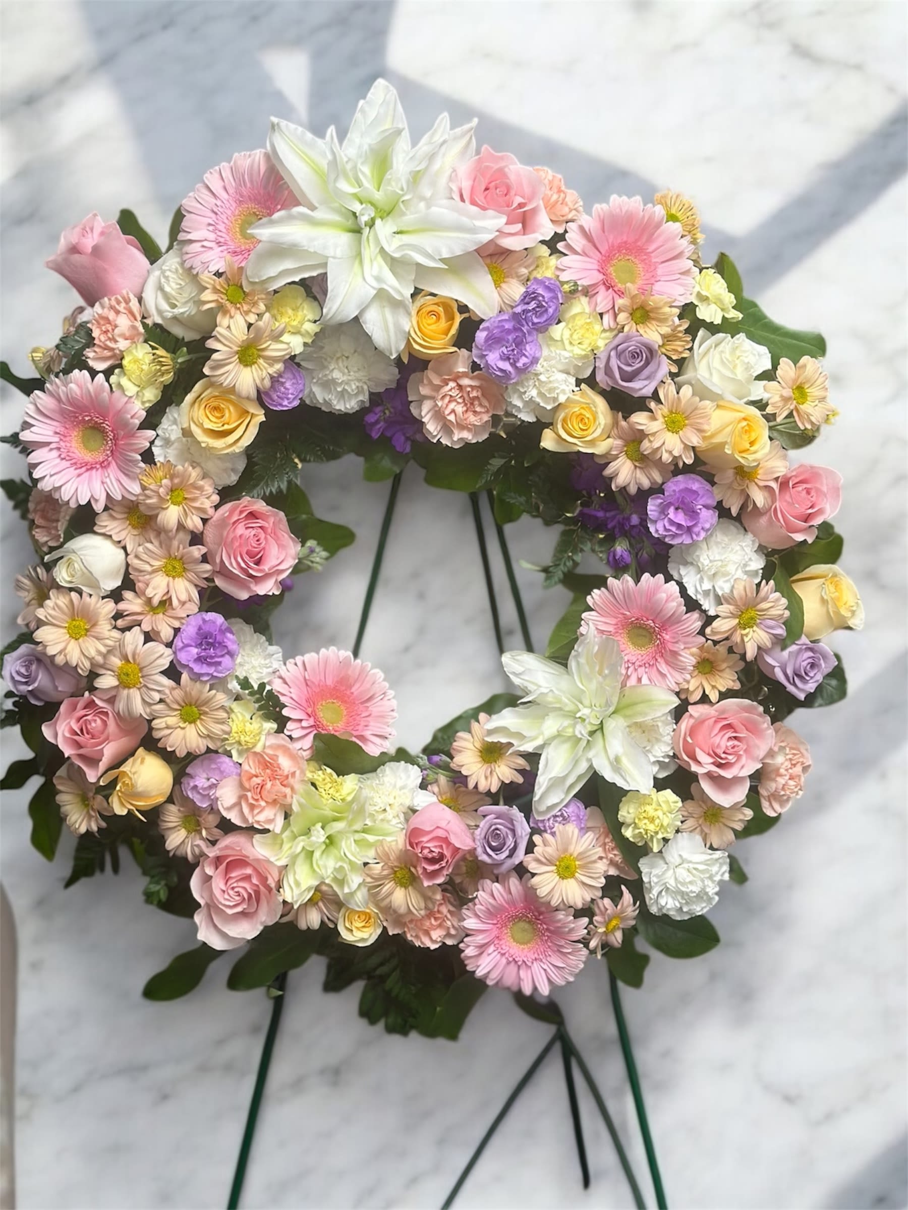 Heart-shaped floral wreath with pink, white, and lavender blooms